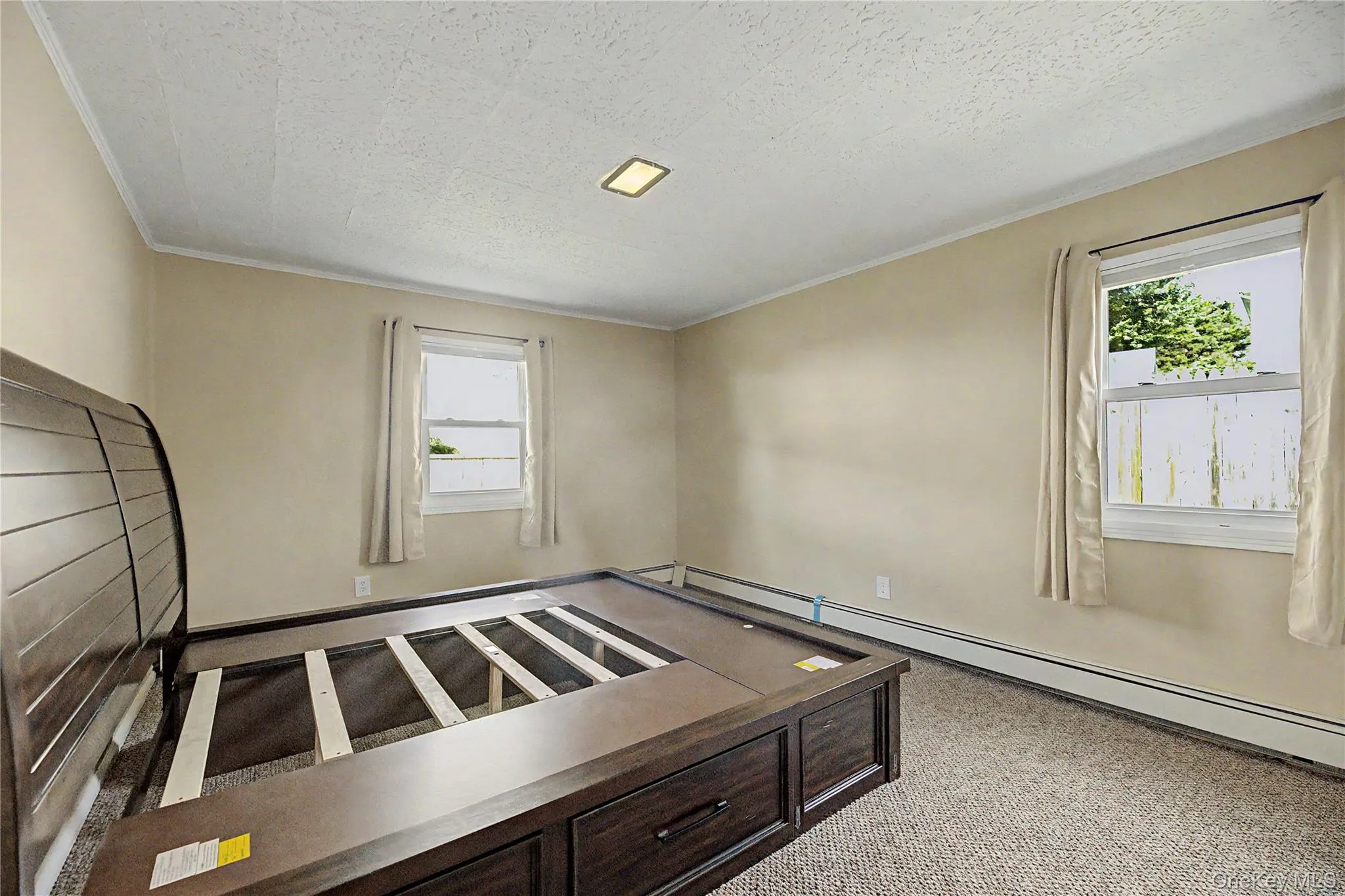 Carpeted flooring, two windows, crown molding, and a recessed ceiling light Carpeted flooring, two windows, crown molding, and a recessed ceiling light