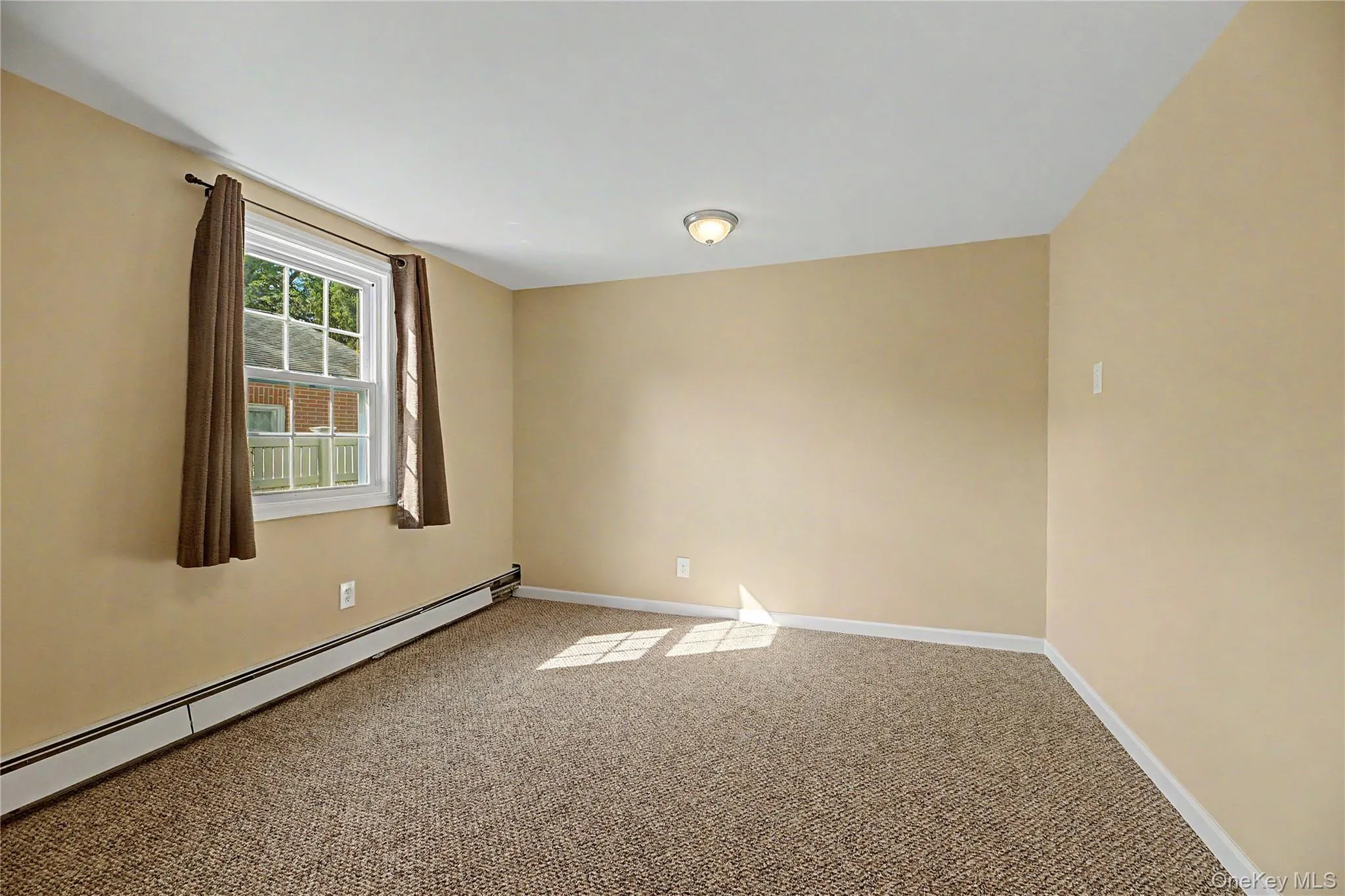 Bright and spacious bedroom featuring neutral décor, carpeted flooring, and abundant natural light from a multi-pane window Bright and spacious bedroom featuring neutral décor, carpeted flooring, and abundant natural light from a multi-pane window