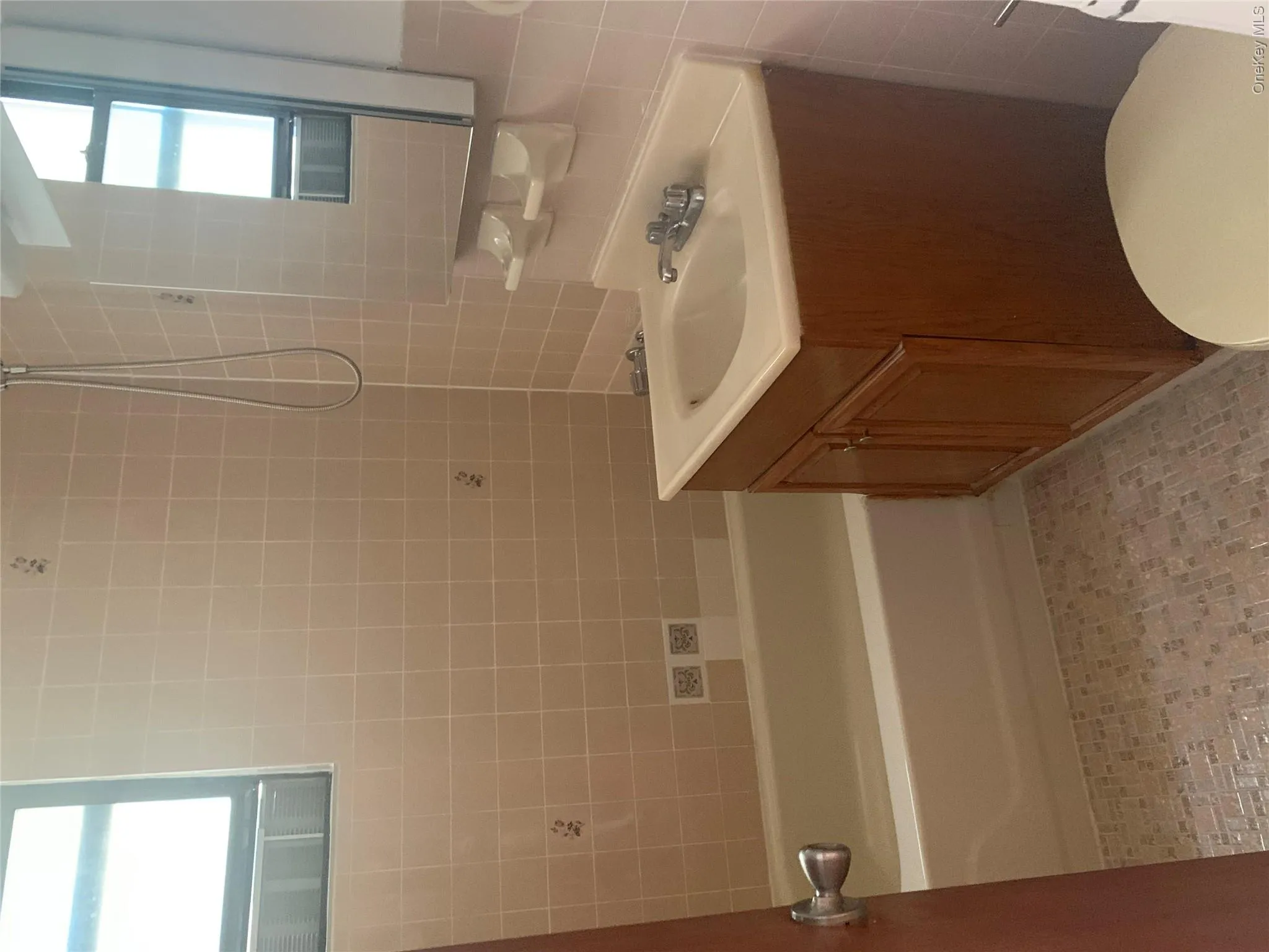 Bathroom featuring a combination bathtub and shower with a handheld showerhead Bathroom featuring a combination bathtub and shower with a handheld showerhead