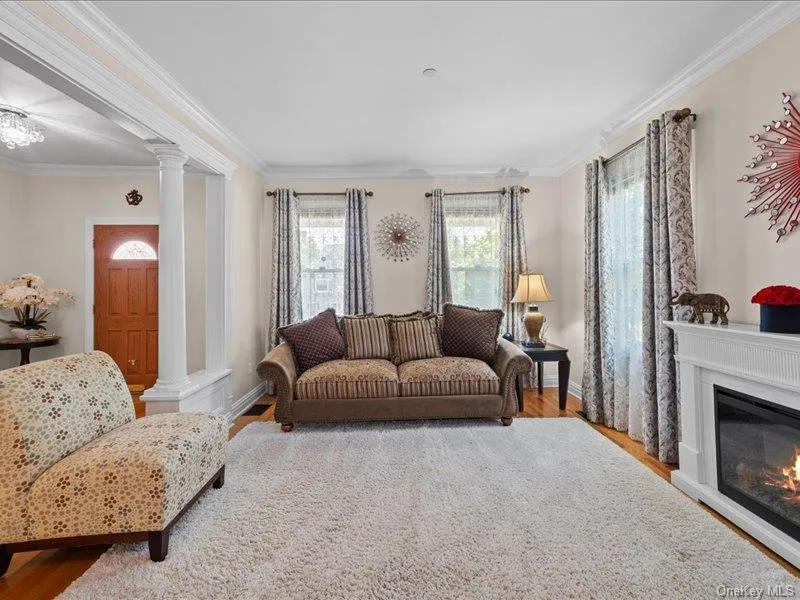 Living area featuring crown molding, decorative columns, hardwood floors, fireplace Living area featuring crown molding, decorative columns, hardwood floors, fireplace
