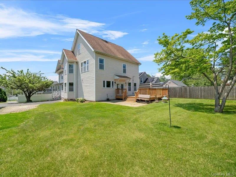 Rear view of house with a wooden deck and roof with shingles Rear view of house with a wooden deck and roof with shingles