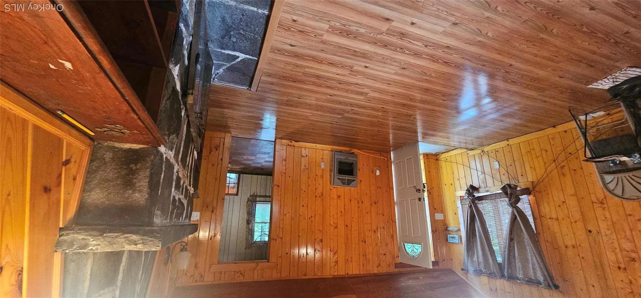 Wood-finish flooring throughout, complemented by wood paneling on walls and ceiling Wood-finish flooring throughout, complemented by wood paneling on walls and ceiling
