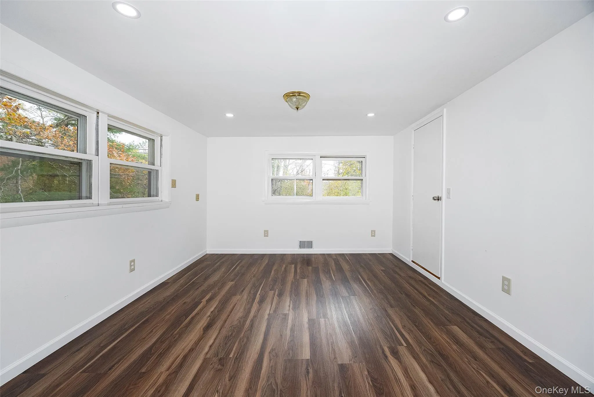 Empty room featuring dark wood-style floors and recessed lighting Empty room featuring dark wood-style floors and recessed lighting