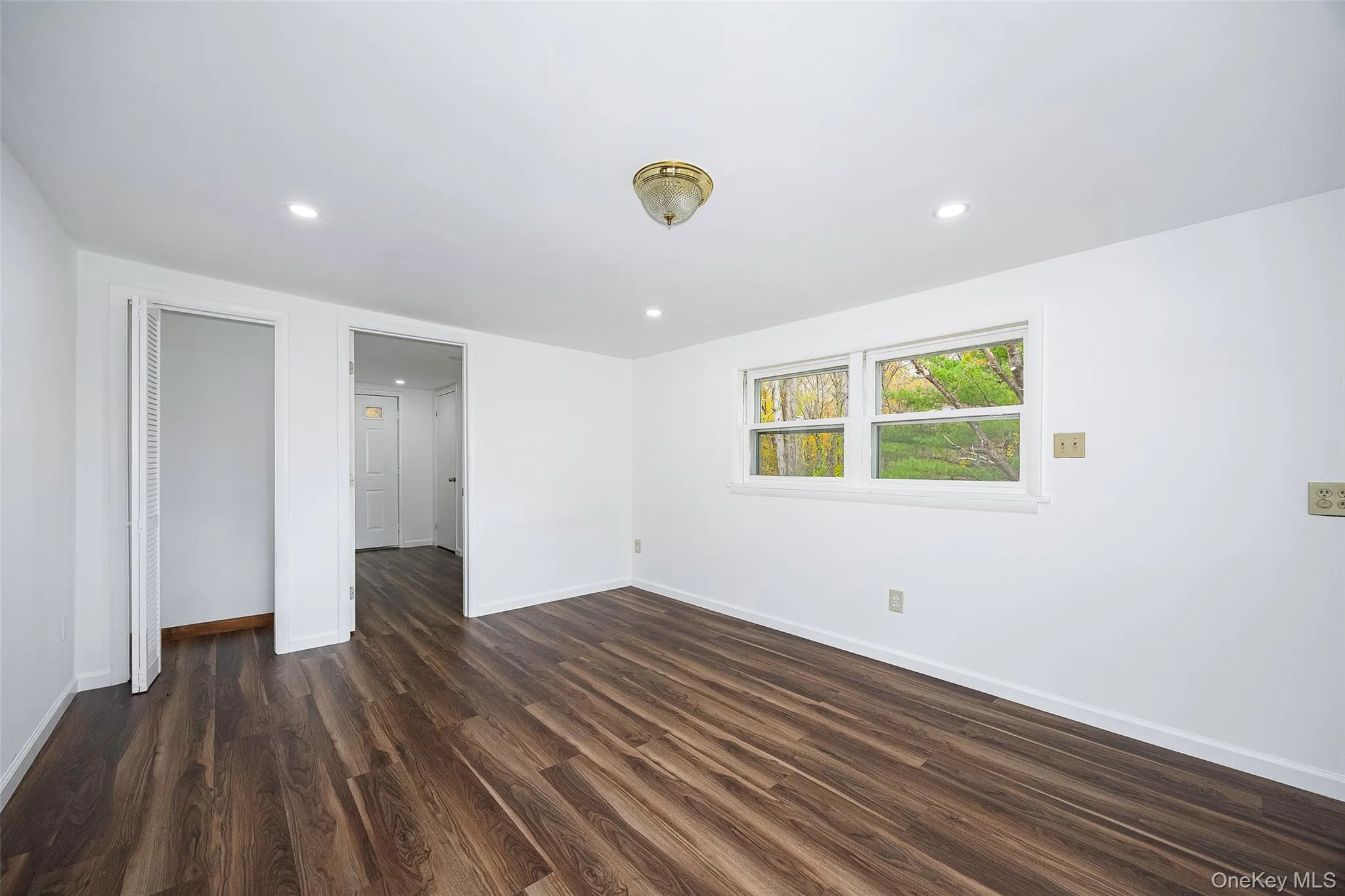 Unfurnished bedroom with dark wood-type flooring and recessed lighting Unfurnished bedroom with dark wood-type flooring and recessed lighting