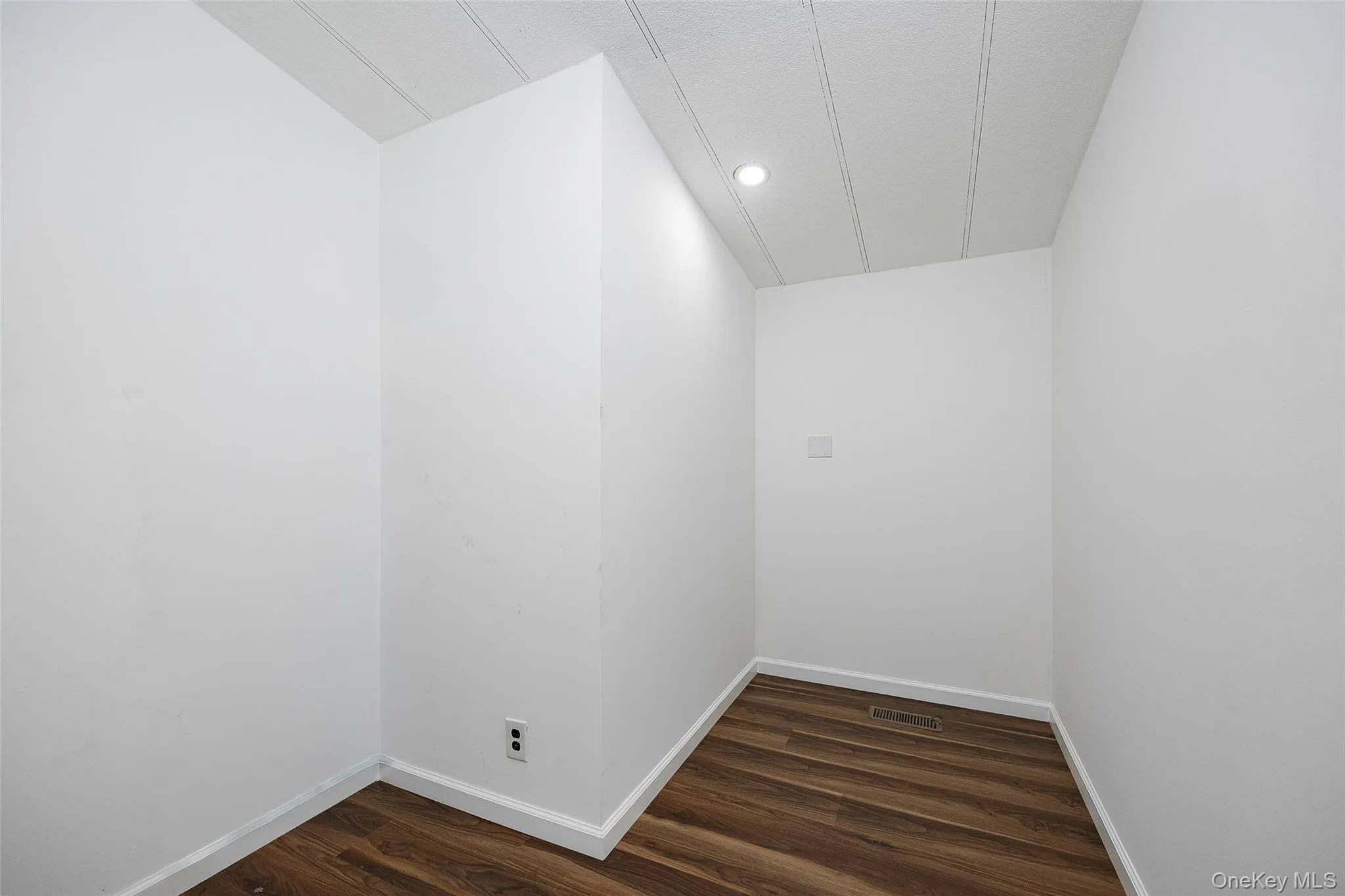 Unfurnished room featuring baseboards and dark wood-type flooring Unfurnished room featuring baseboards and dark wood-type flooring