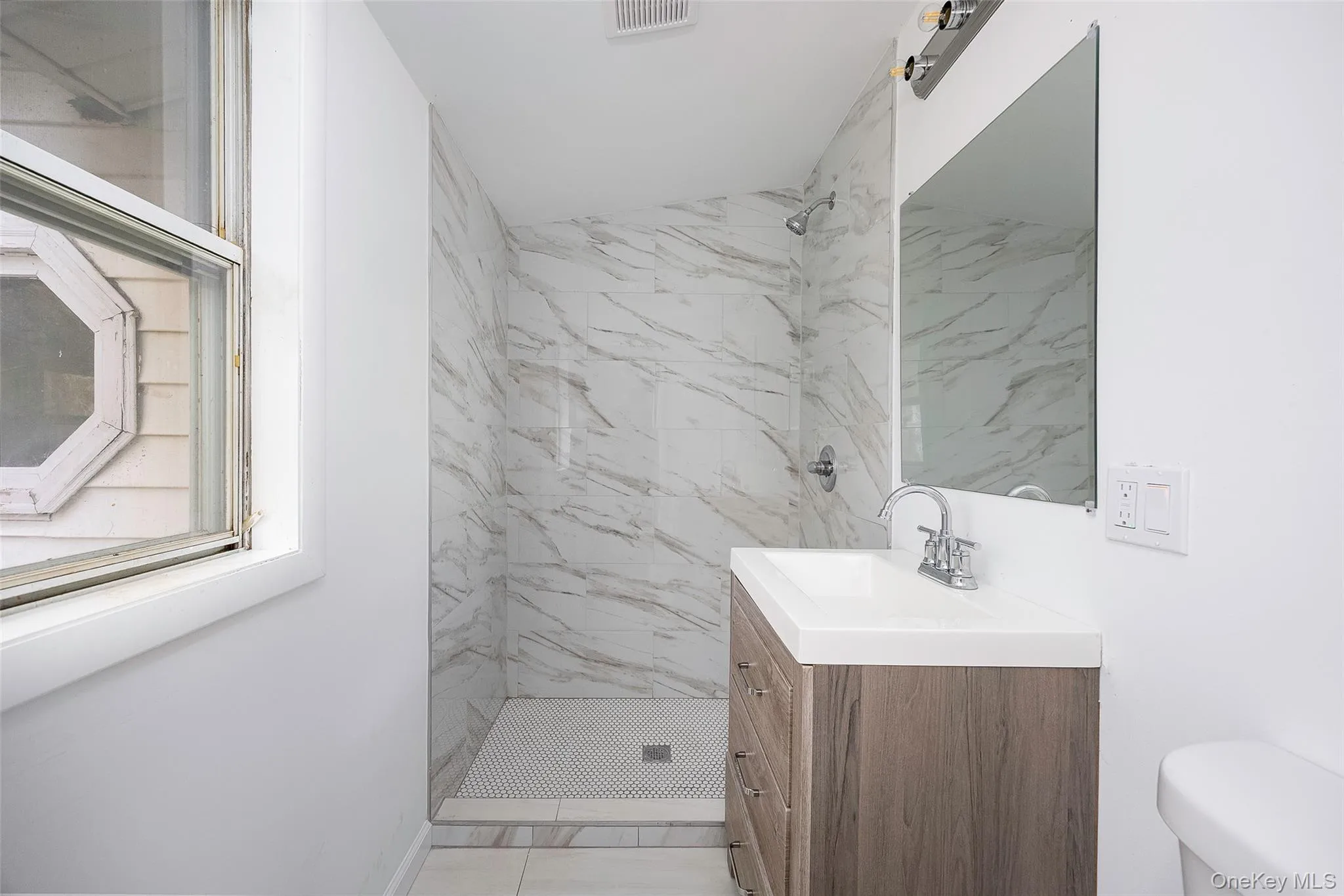 Full bathroom featuring vanity and a marble finish shower Full bathroom featuring vanity and a marble finish shower