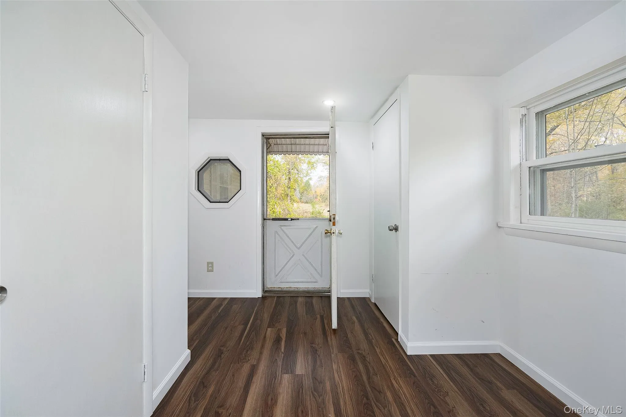 Entryway featuring dark wood-style flooring and baseboards Entryway featuring dark wood-style flooring and baseboards