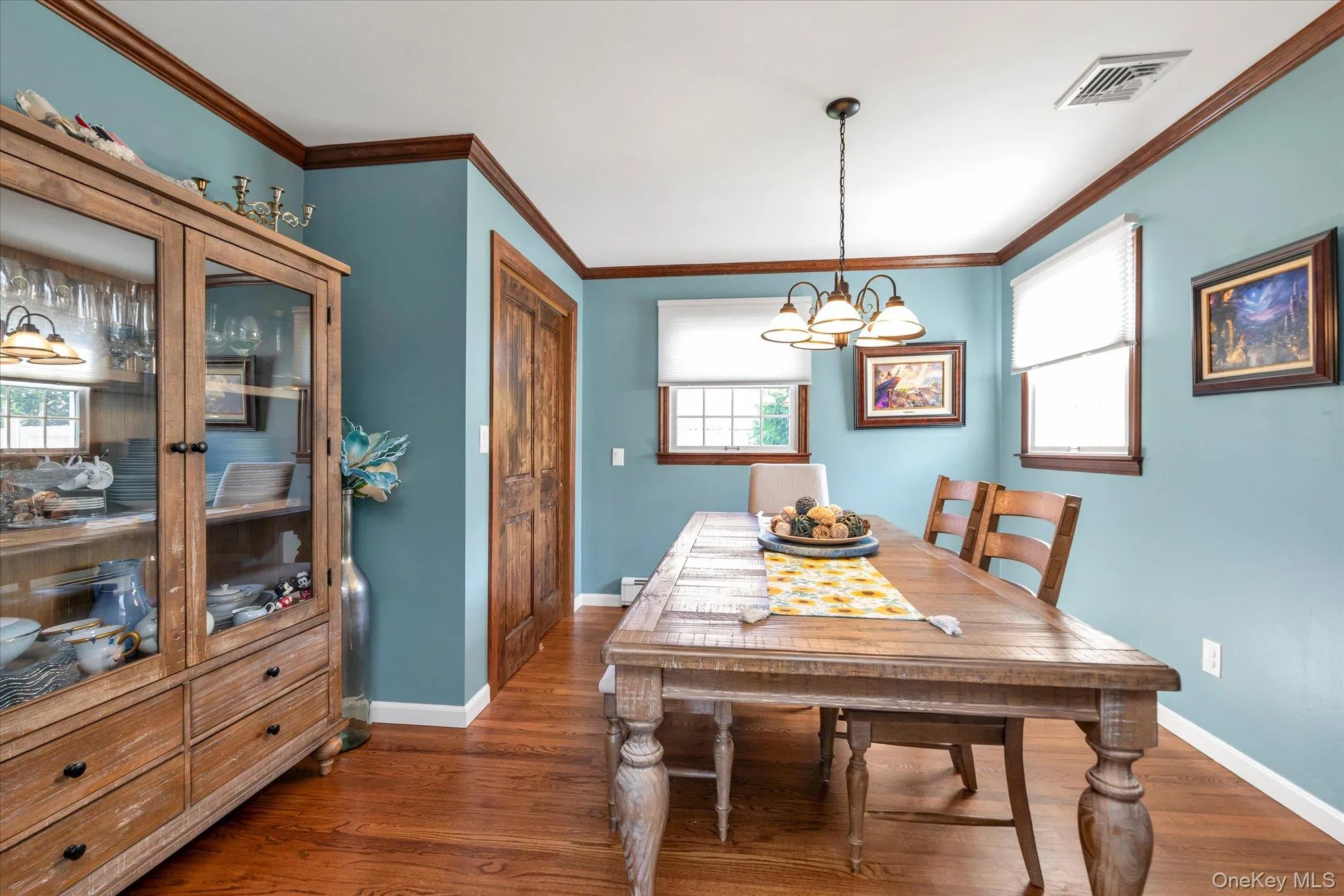 Formal dining room with hardwood floors, crown molding and built-in-cabinetry. Formal dining room with hardwood floors, crown molding and built-in-cabinetry.