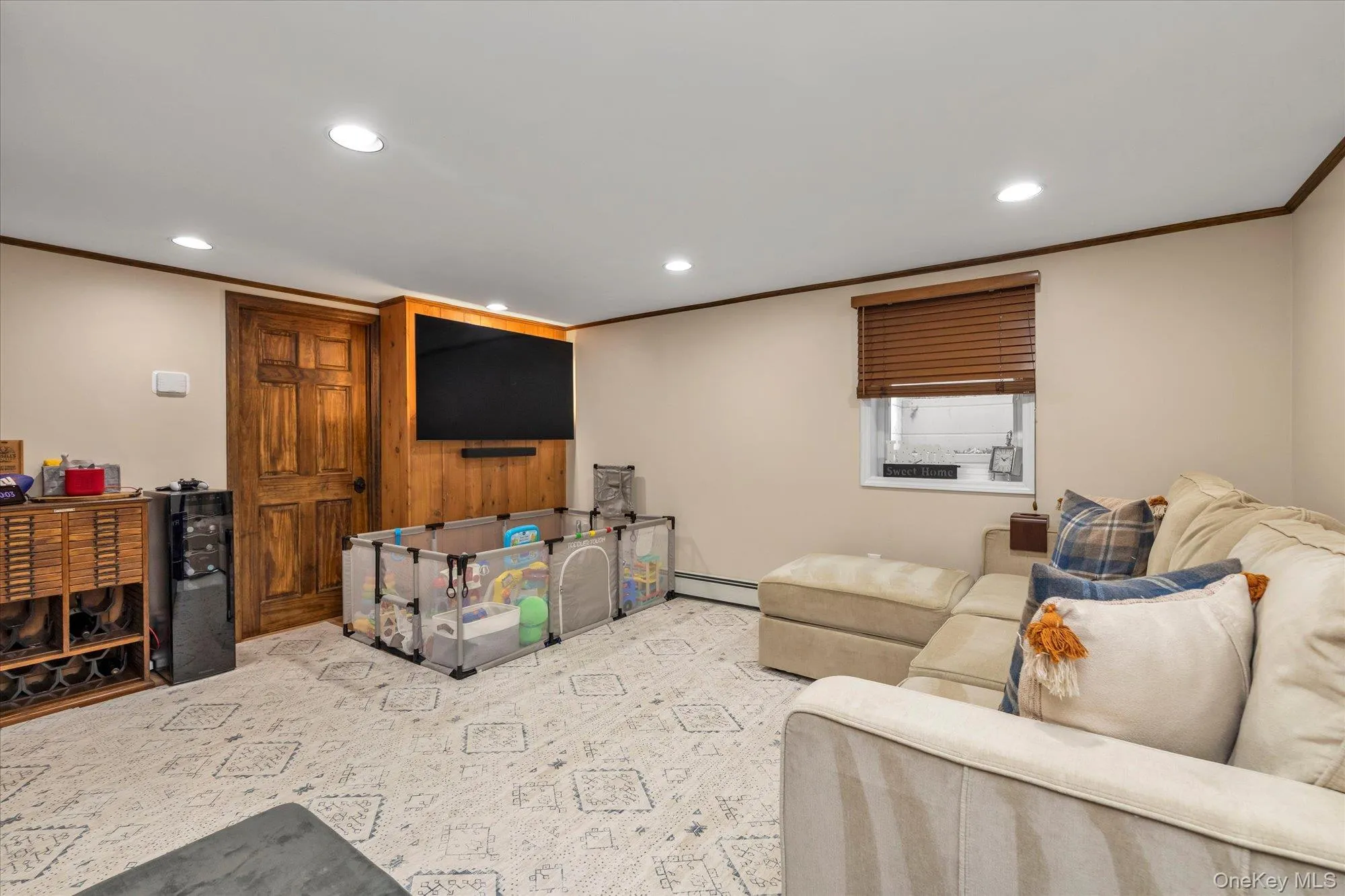 Lower level recreation room with crown molding, new flooring, storage and access to outside garage entrance. Lower level recreation room with crown molding, new flooring, storage and access to outside garage entrance.
