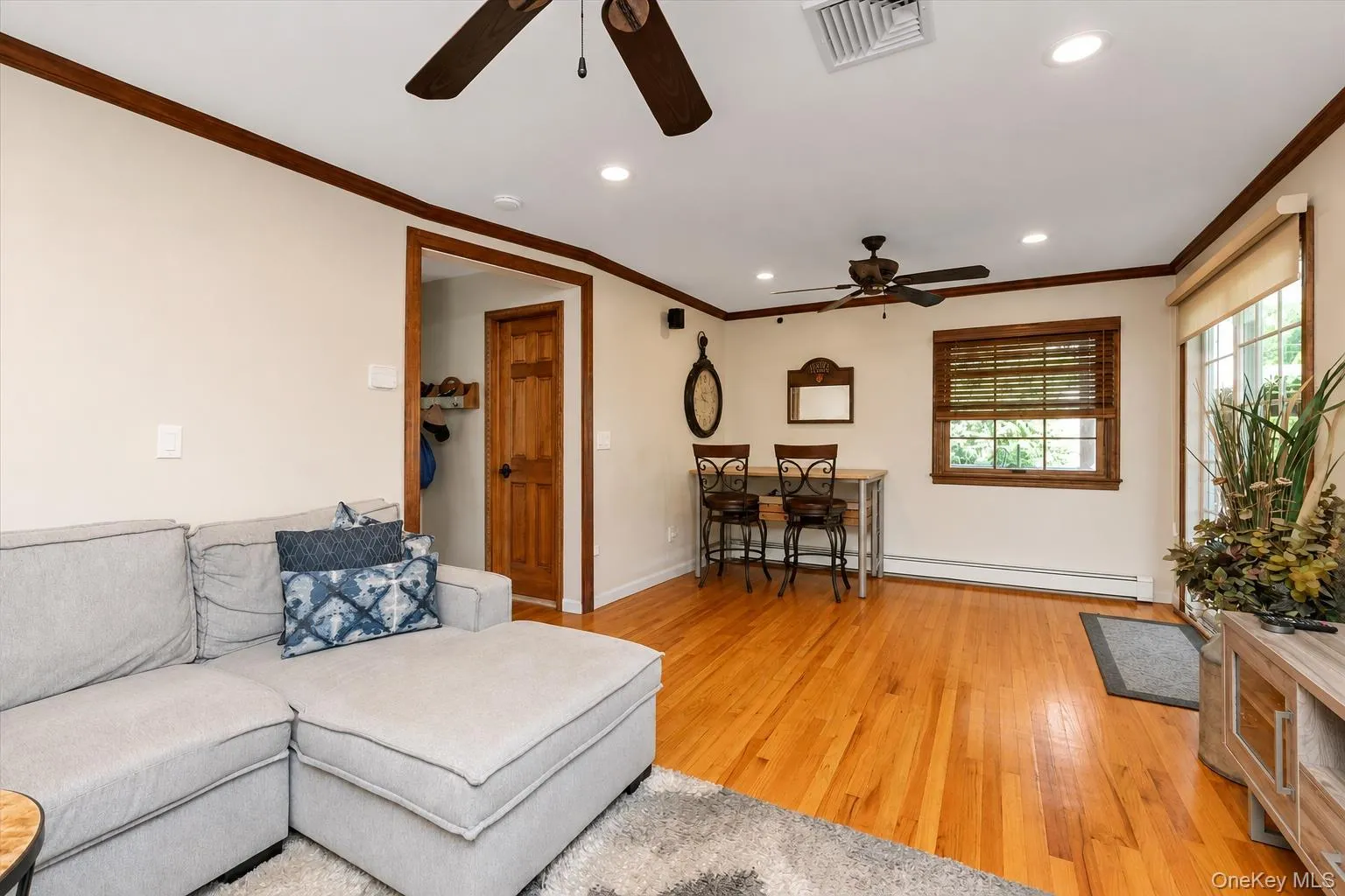 Family room with hardwood floors, crown molding and access to screened-in-porch Family room with hardwood floors, crown molding and access to screened-in-porch