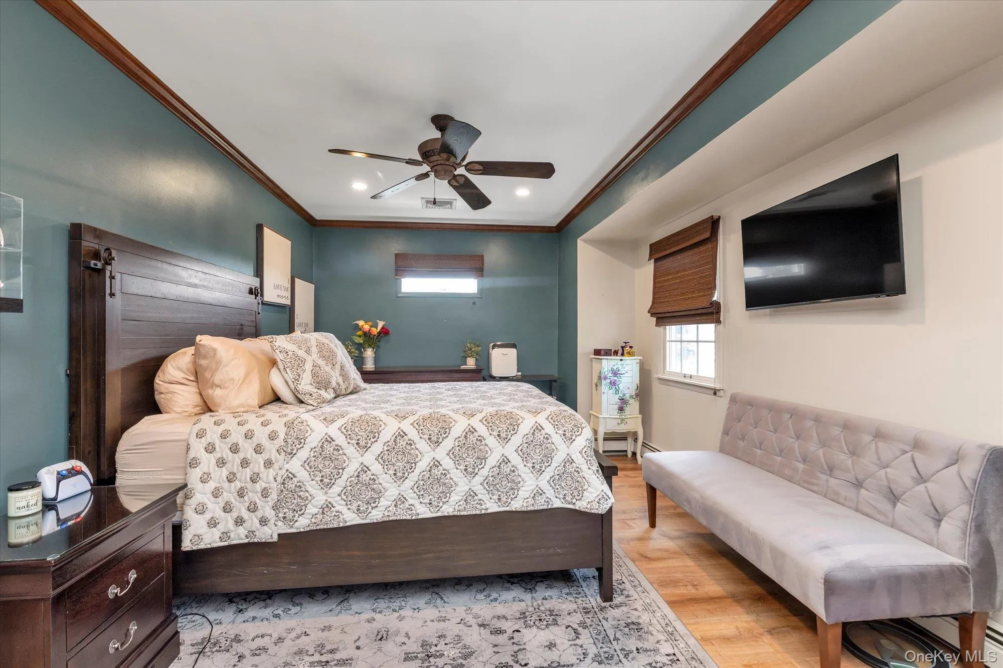 Large primary bedroom with crown molding, transom window, new flooring and double closets. Large primary bedroom with crown molding, transom window, new flooring and double closets.