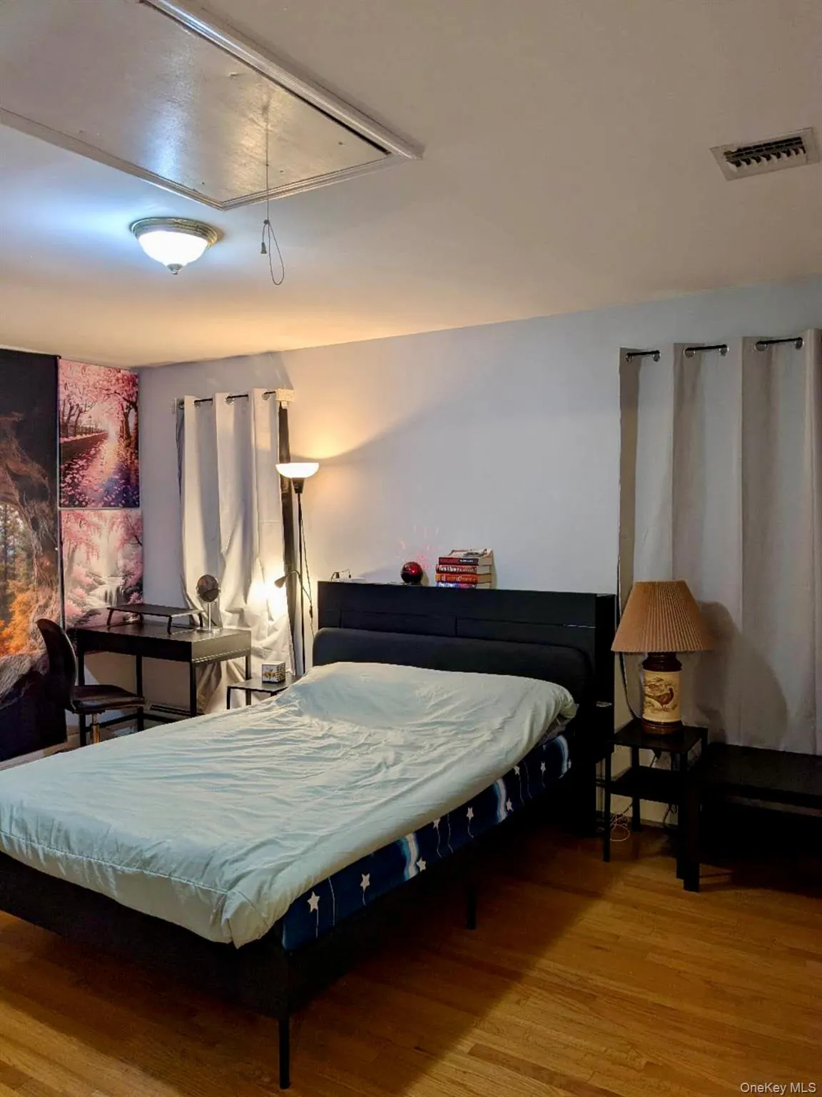Hardwood flooring throughout featuring a ceiling-mounted light fixture, recessed ceiling vent, and attic access panel Hardwood flooring throughout featuring a ceiling-mounted light fixture, recessed ceiling vent, and attic access panel