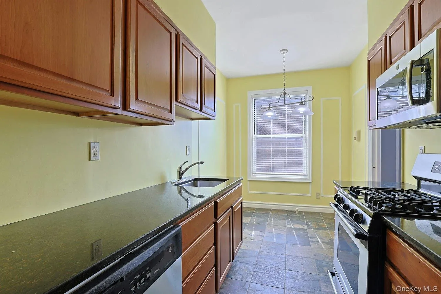 Windowed Eat-In Kitchen with Granite Countertops and Ample Cabinetry Windowed Eat-In Kitchen with Granite Countertops and Ample Cabinetry