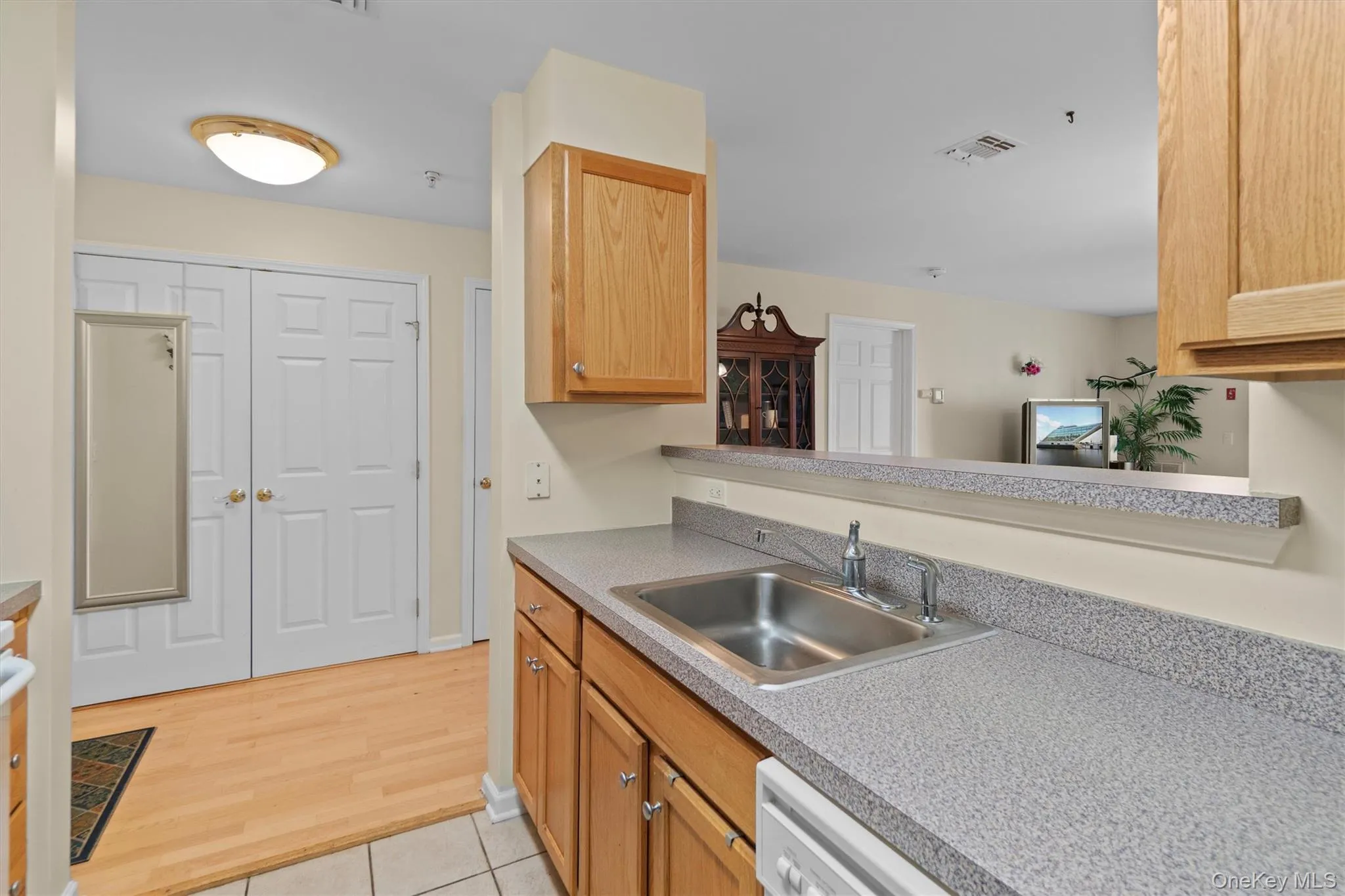Kitchen featuring light countertops, light wood-style floors, and a sink Kitchen featuring light countertops, light wood-style floors, and a sink