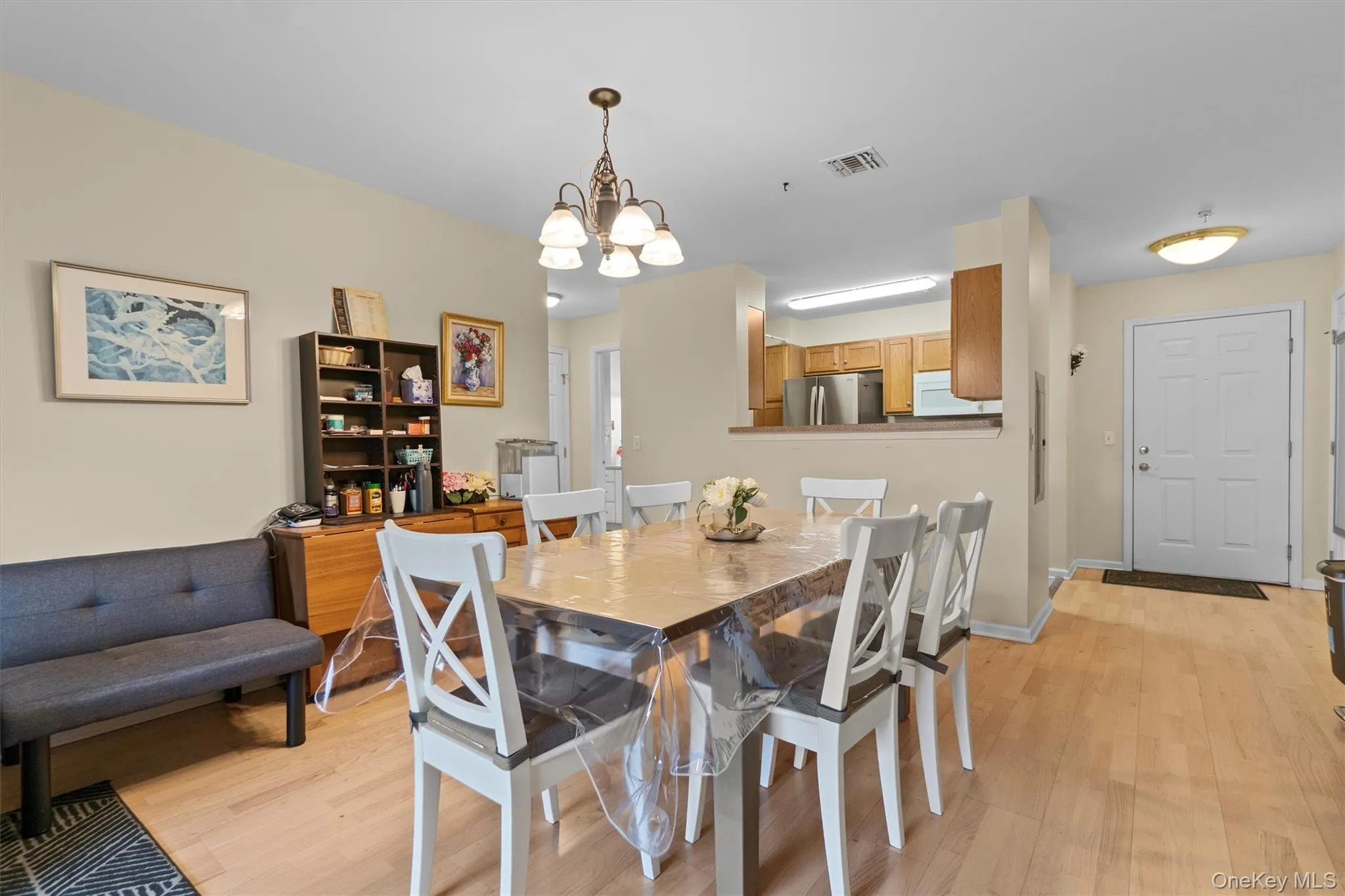 Dining space featuring light wood-type flooring and an inviting chandelier Dining space featuring light wood-type flooring and an inviting chandelier