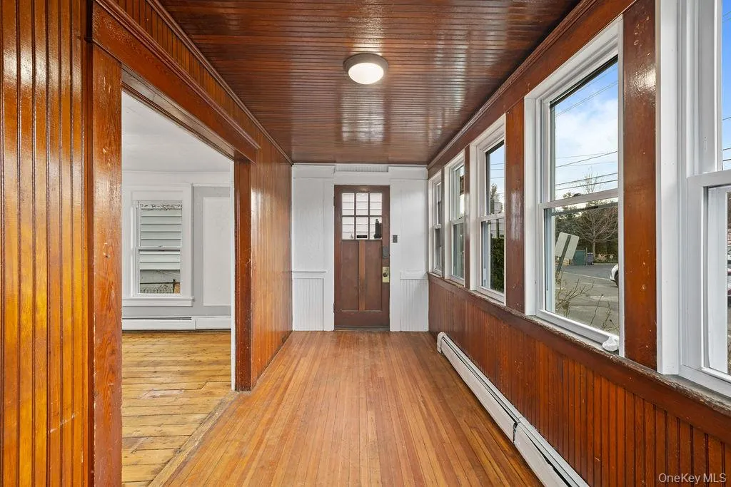 Doorway with baseboard heating, light hardwood / wood-style flooring, and plenty of natural light Doorway with baseboard heating, light hardwood / wood-style flooring, and plenty of natural light