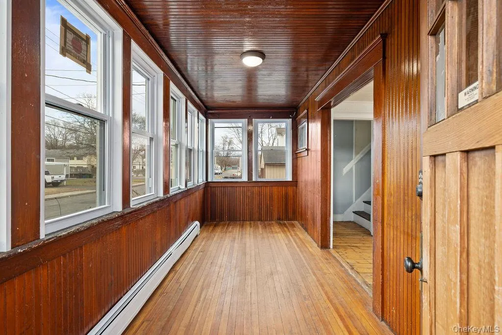 Unfurnished sunroom featuring wood ceiling and a baseboard radiator Unfurnished sunroom featuring wood ceiling and a baseboard radiator