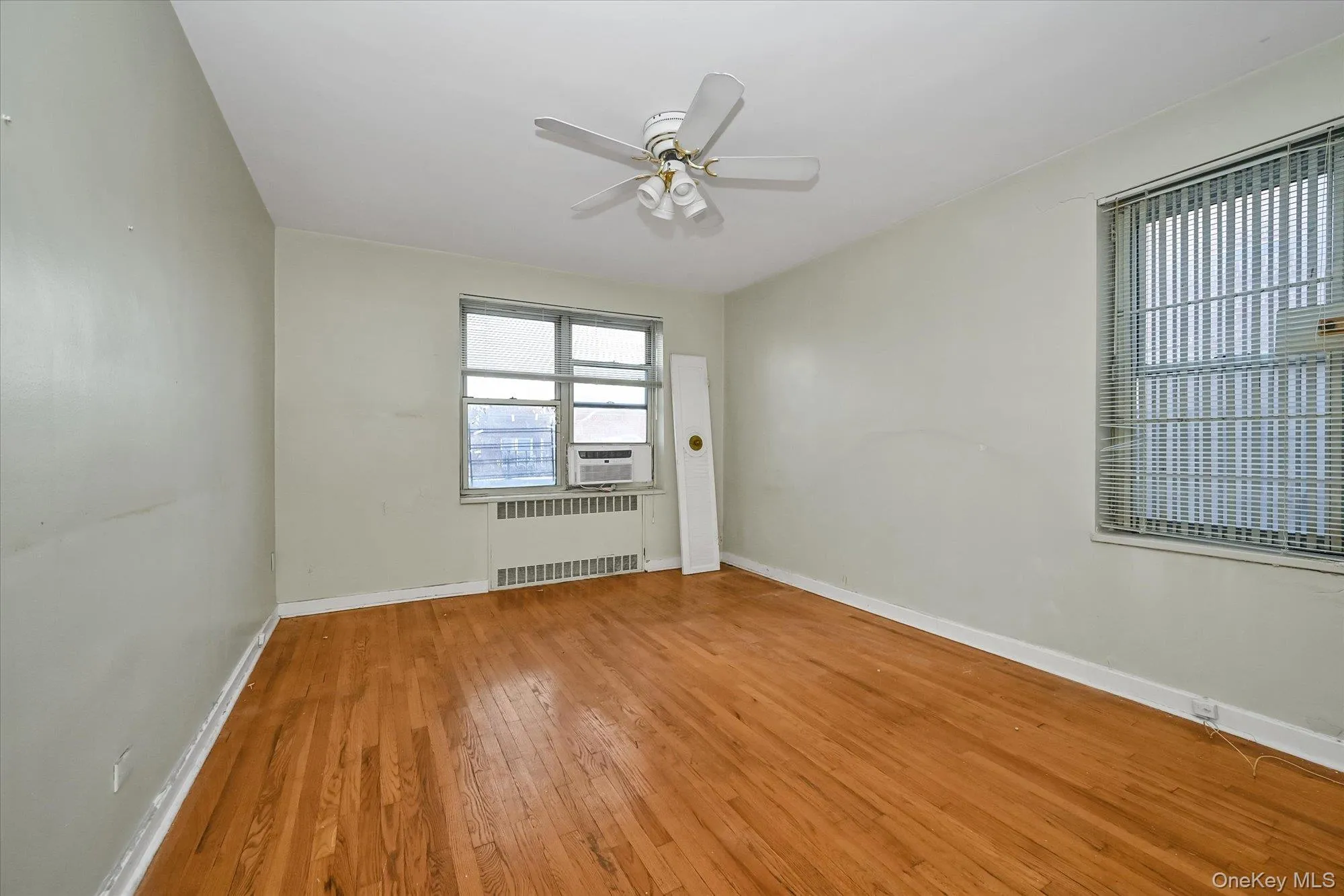 Hardwood flooring throughout, ceiling fan with integrated lighting, and multiple windows providing natural illumination Hardwood flooring throughout, ceiling fan with integrated lighting, and multiple windows providing natural illumination
