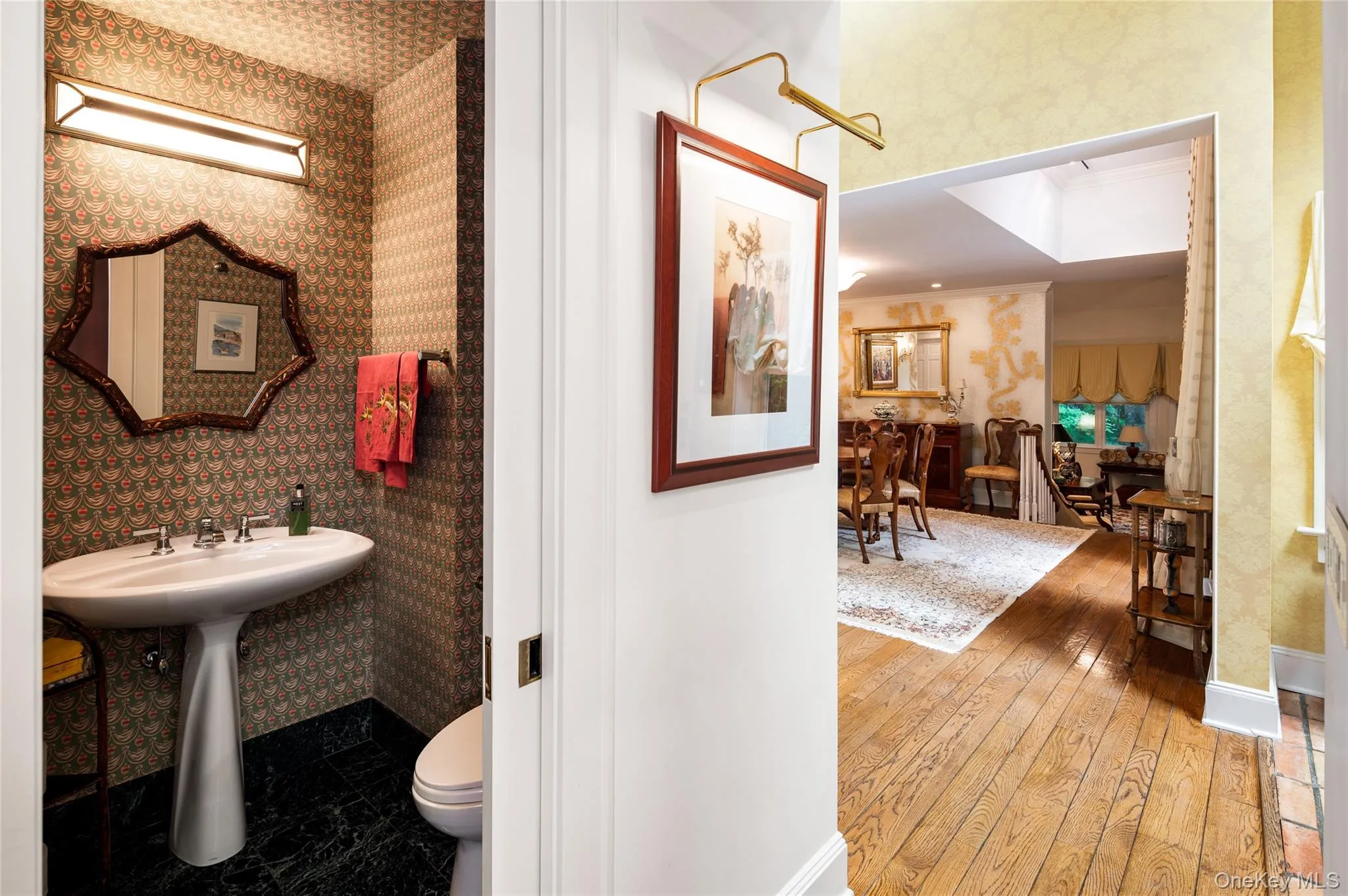 Guest half bath on first floor and view to formal dining room and formal living room beyond. Guest half bath on first floor and view to formal dining room and formal living room beyond.