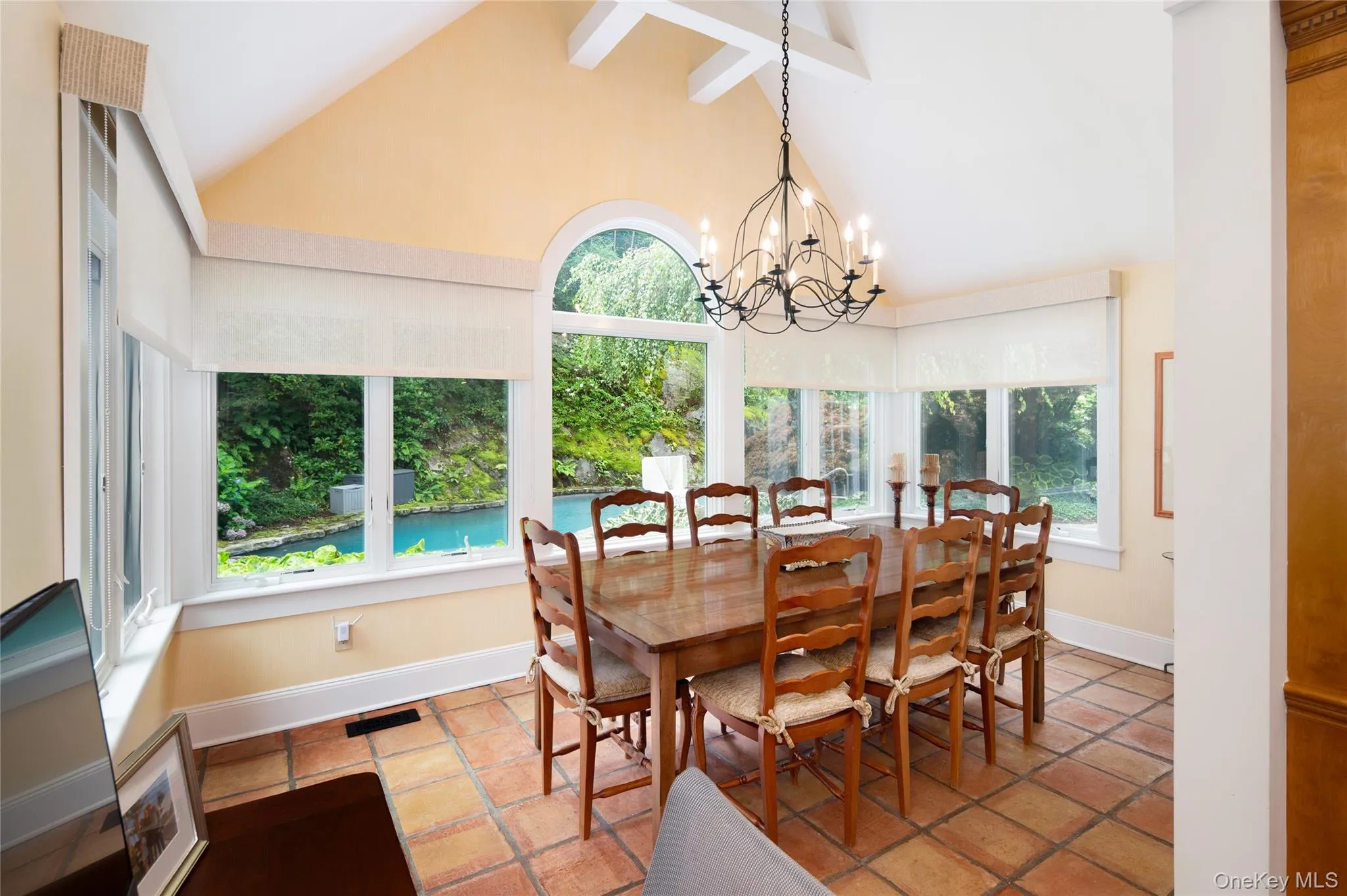 View of solarium vaulted ceiling and beams and view of pool. View of solarium vaulted ceiling and beams and view of pool.