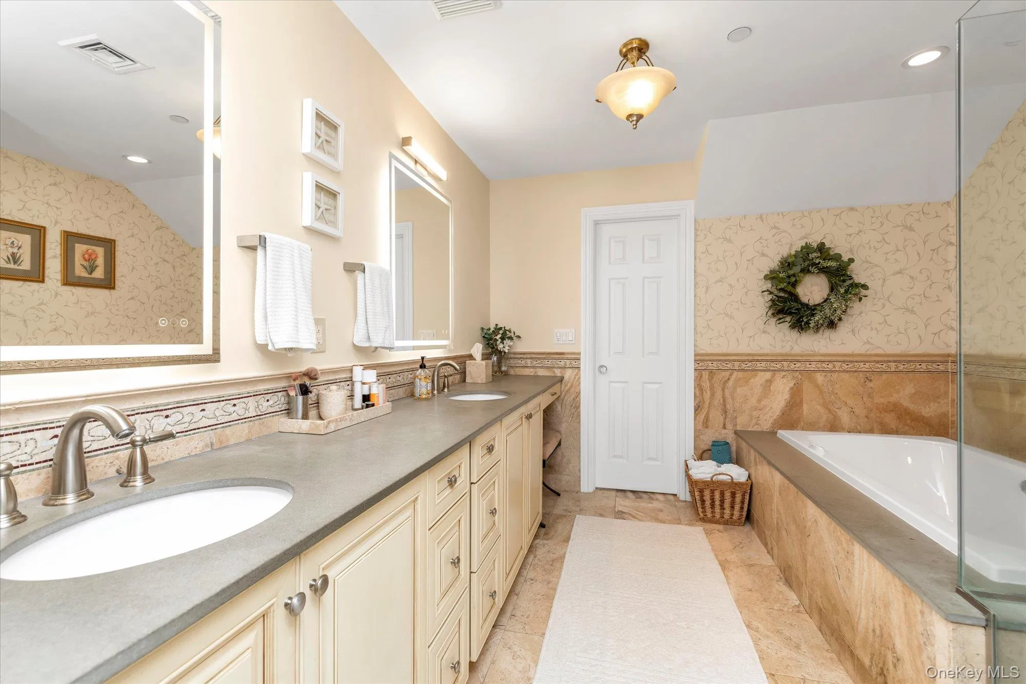 Bathroom featuring an expansive double vanity with integrated sinks, brushed nickel faucets, and a neutral countertop-spa tub Bathroom featuring an expansive double vanity with integrated sinks, brushed nickel faucets, and a neutral countertop-spa tub