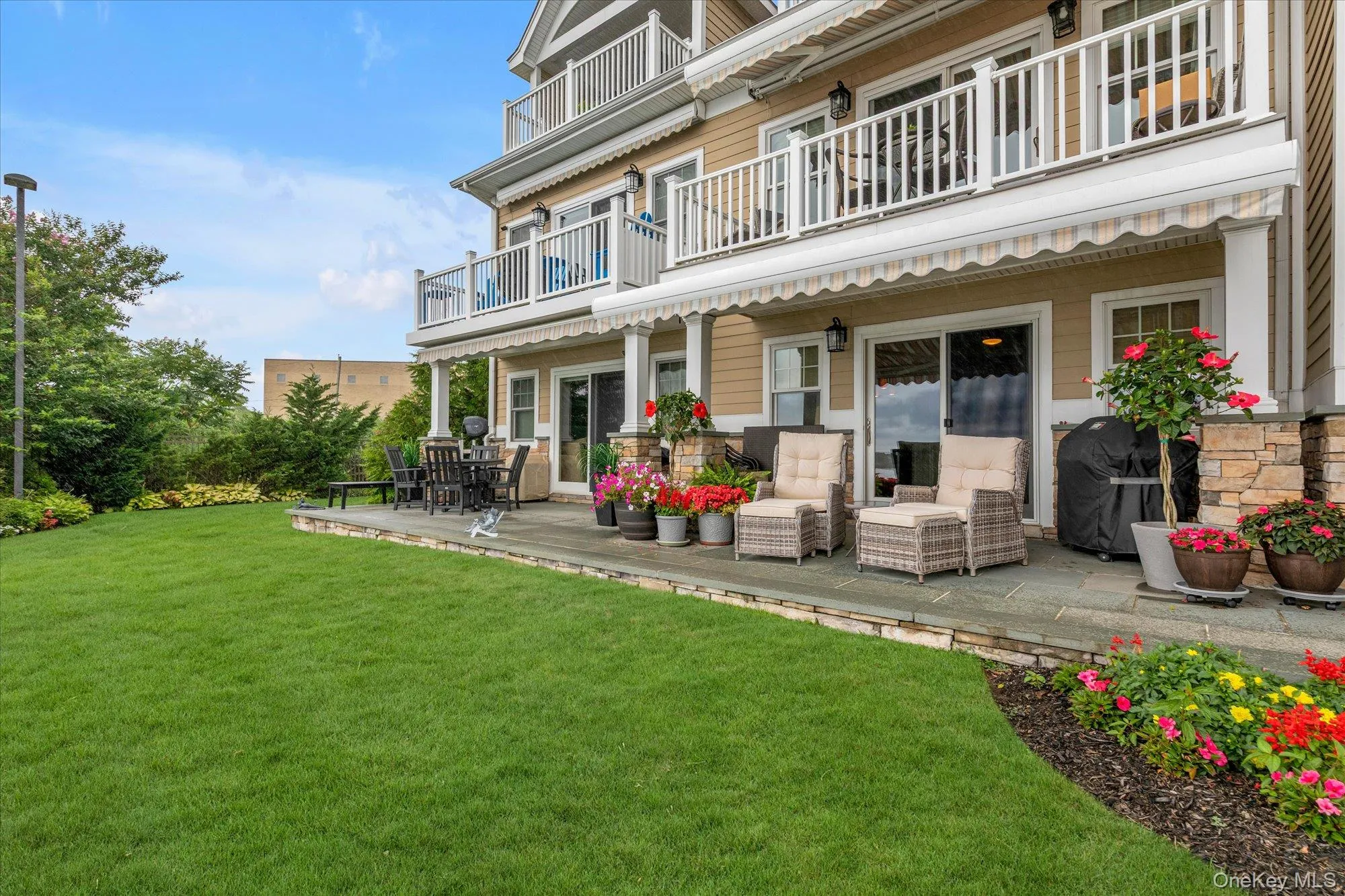Expansive green lawn with a curved planted bed featuring vibrant flowers Expansive green lawn with a curved planted bed featuring vibrant flowers
