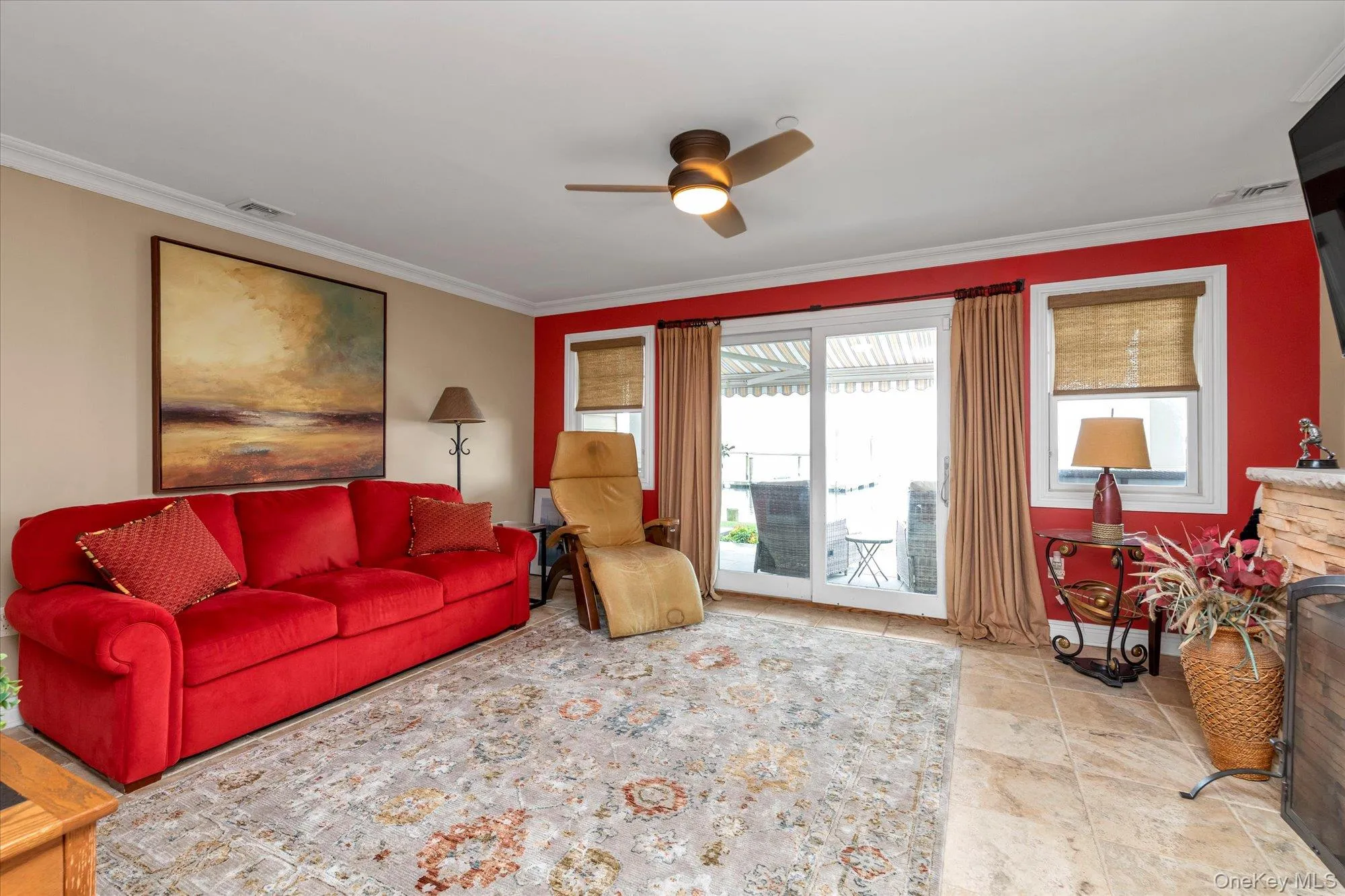 Spacious living area featuring tile flooring, a ceiling fan with integrated lighting, and crown molding-Sliders to first floor patio Spacious living area featuring tile flooring, a ceiling fan with integrated lighting, and crown molding-Sliders to first floor patio