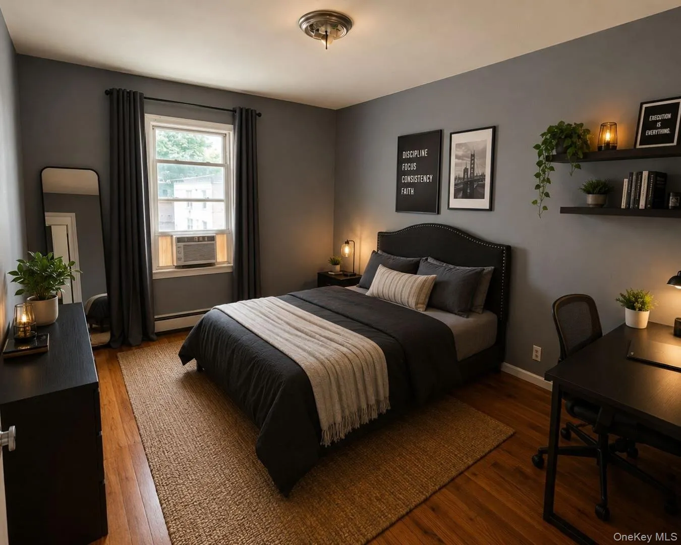Bedroom featuring wood-finish flooring, neutral gray walls, and a window with dark curtains Bedroom featuring wood-finish flooring, neutral gray walls, and a window with dark curtains