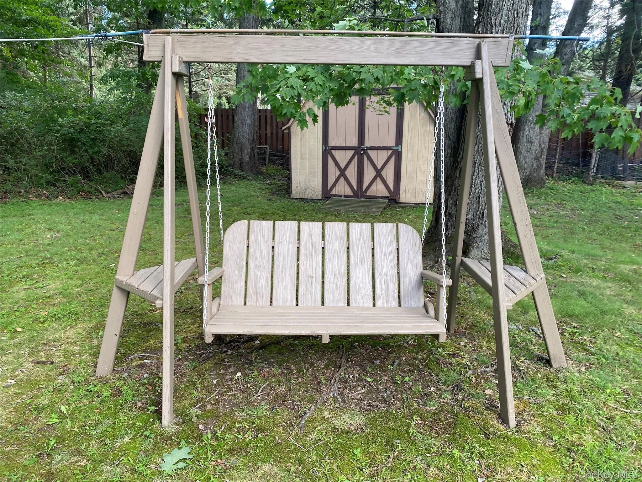 Freshly painted swing set in a spacious private backyard Freshly painted swing set in a spacious private backyard