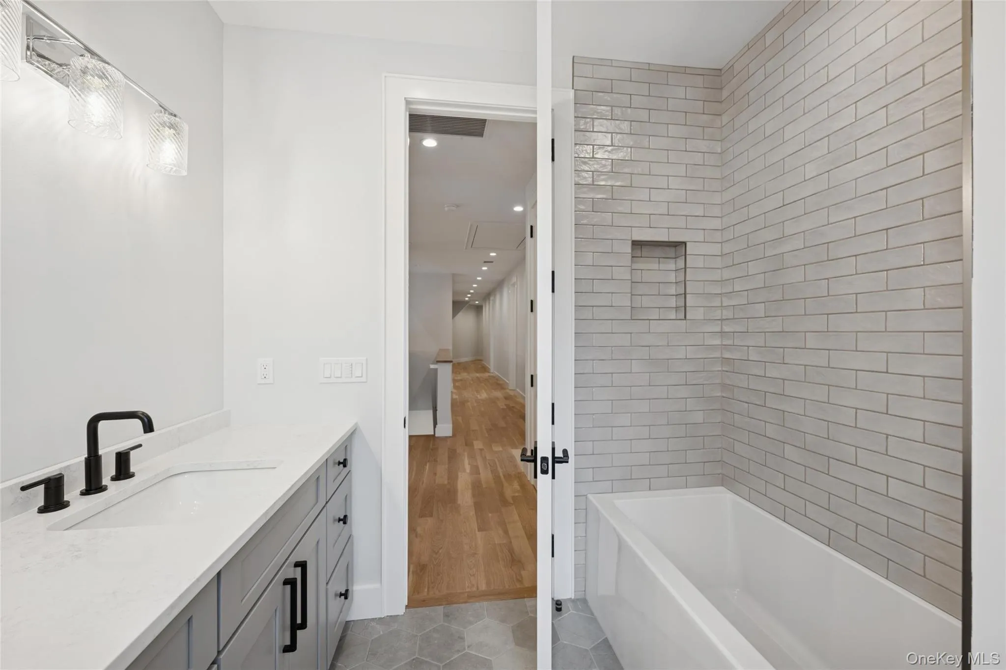 Bathroom featuring vanity, shower / washtub combination, light tile patterned floors, and recessed lighting Bathroom featuring vanity, shower / washtub combination, light tile patterned floors, and recessed lighting