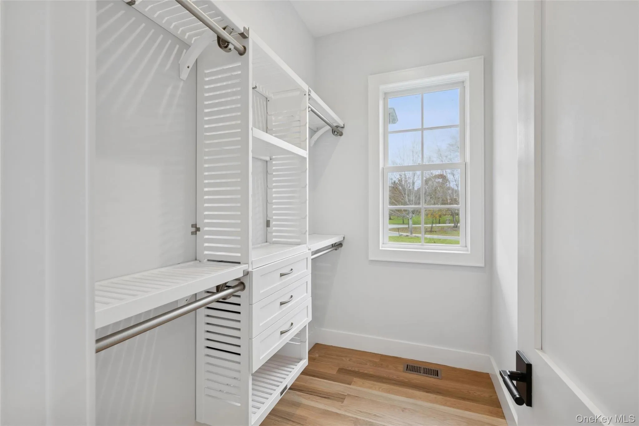 Spacious closet with light wood-style floors Spacious closet with light wood-style floors