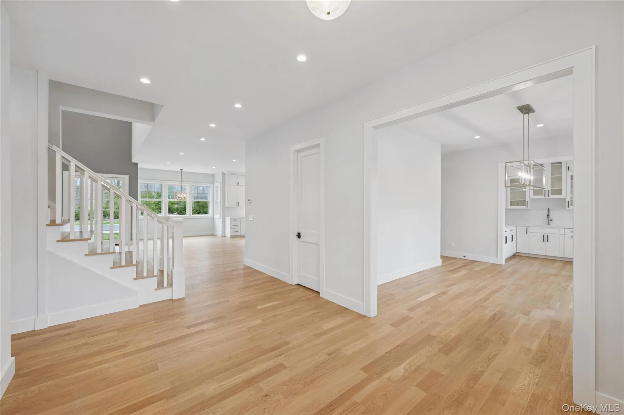 Hallway featuring recessed lighting, stairs, and light wood-style flooring Hallway featuring recessed lighting, stairs, and light wood-style flooring