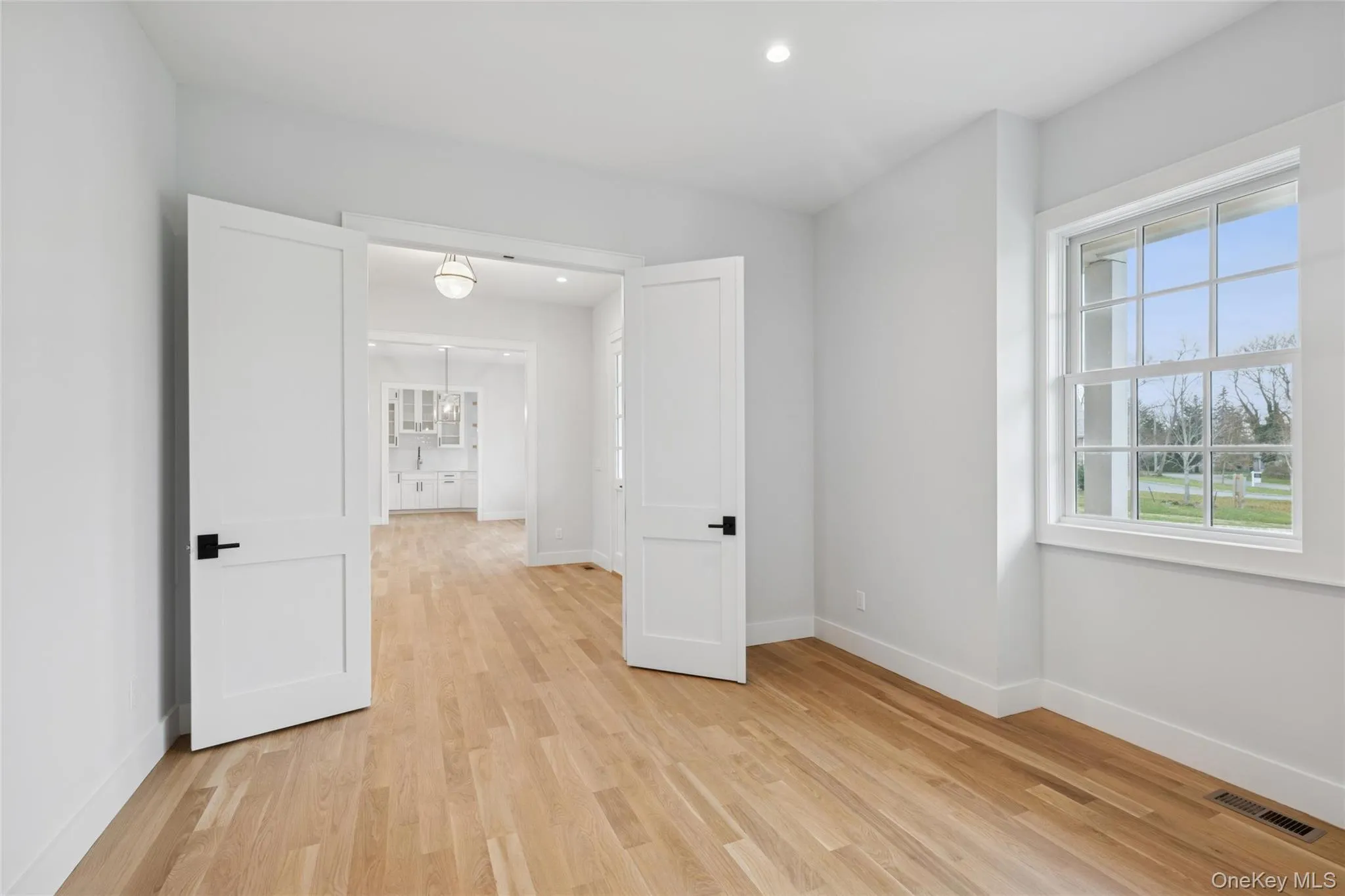 Office with light wood-style flooring and recessed lighting Office with light wood-style flooring and recessed lighting