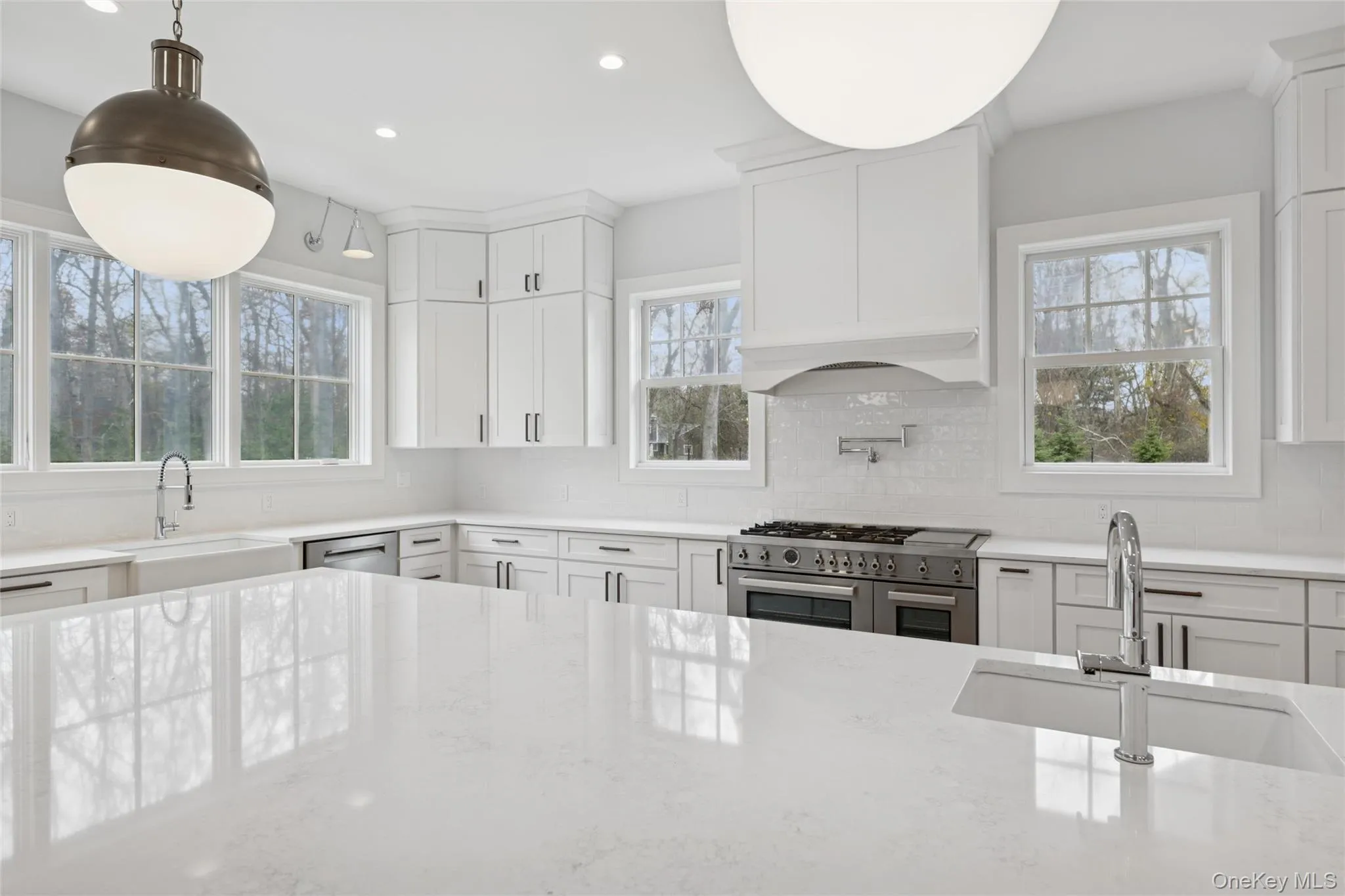 Kitchen with stainless steel appliances, white cabinetry, light stone counters, recessed lighting, and tasteful backsplash Kitchen with stainless steel appliances, white cabinetry, light stone counters, recessed lighting, and tasteful backsplash