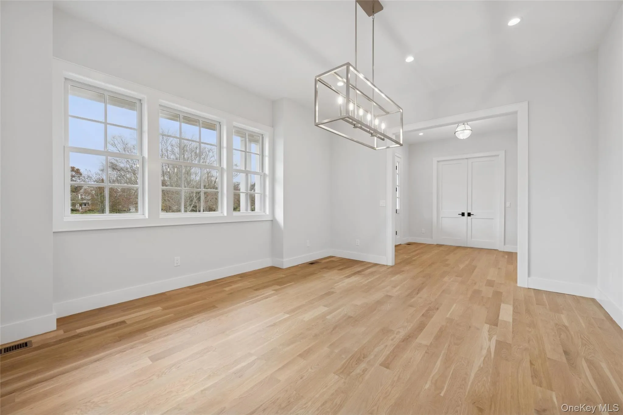 Unfurnished dining area featuring light wood finished floors, a chandelier, and recessed lighting Unfurnished dining area featuring light wood finished floors, a chandelier, and recessed lighting
