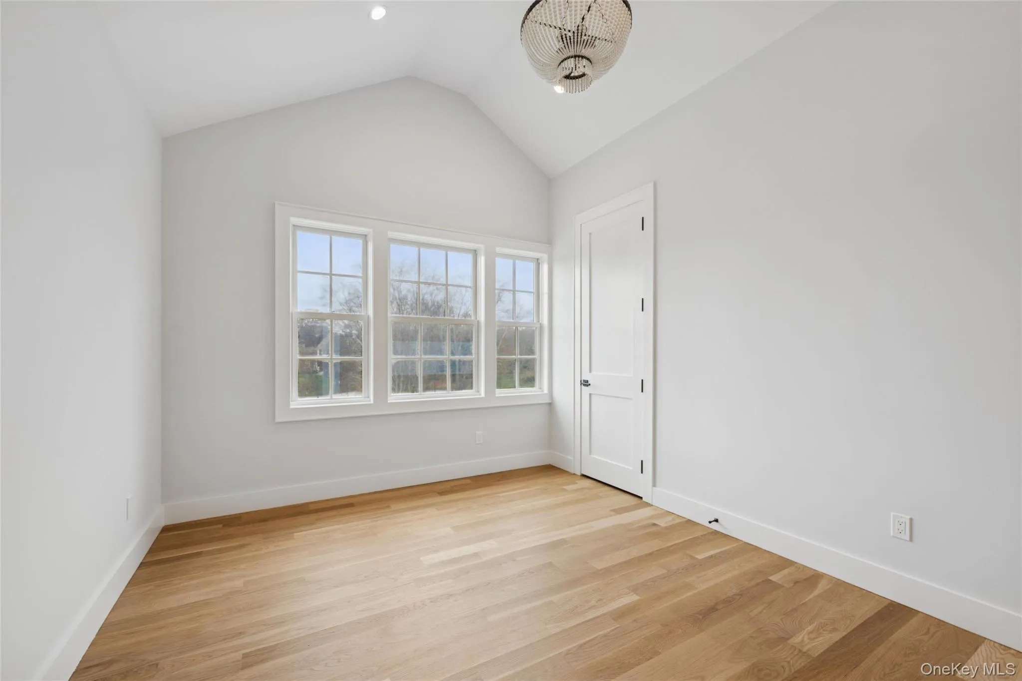 Bedroom with lofted ceiling and light wood finished floors Bedroom with lofted ceiling and light wood finished floors