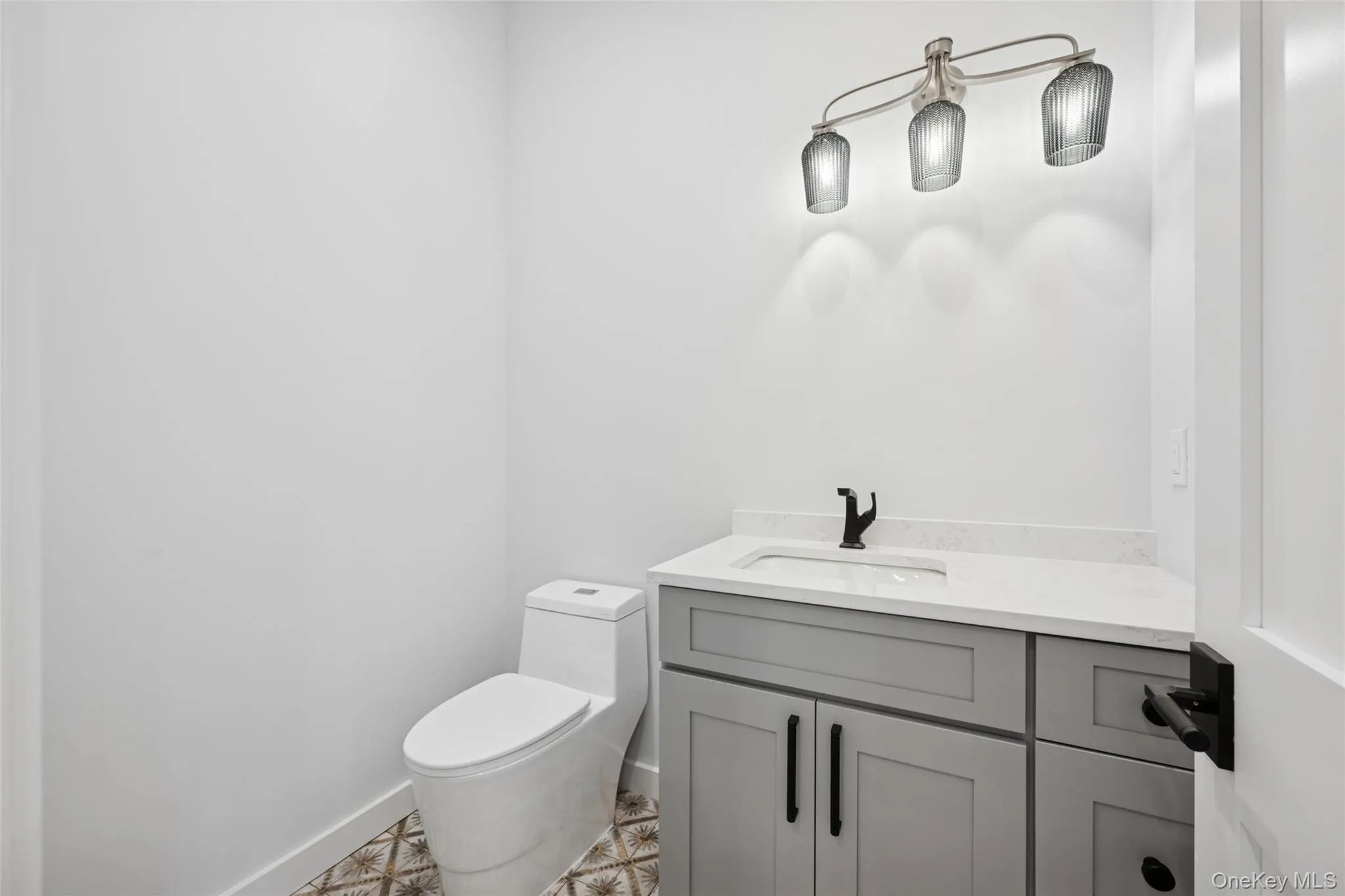 Half bath featuring vanity and toilet Half bath featuring vanity and toilet