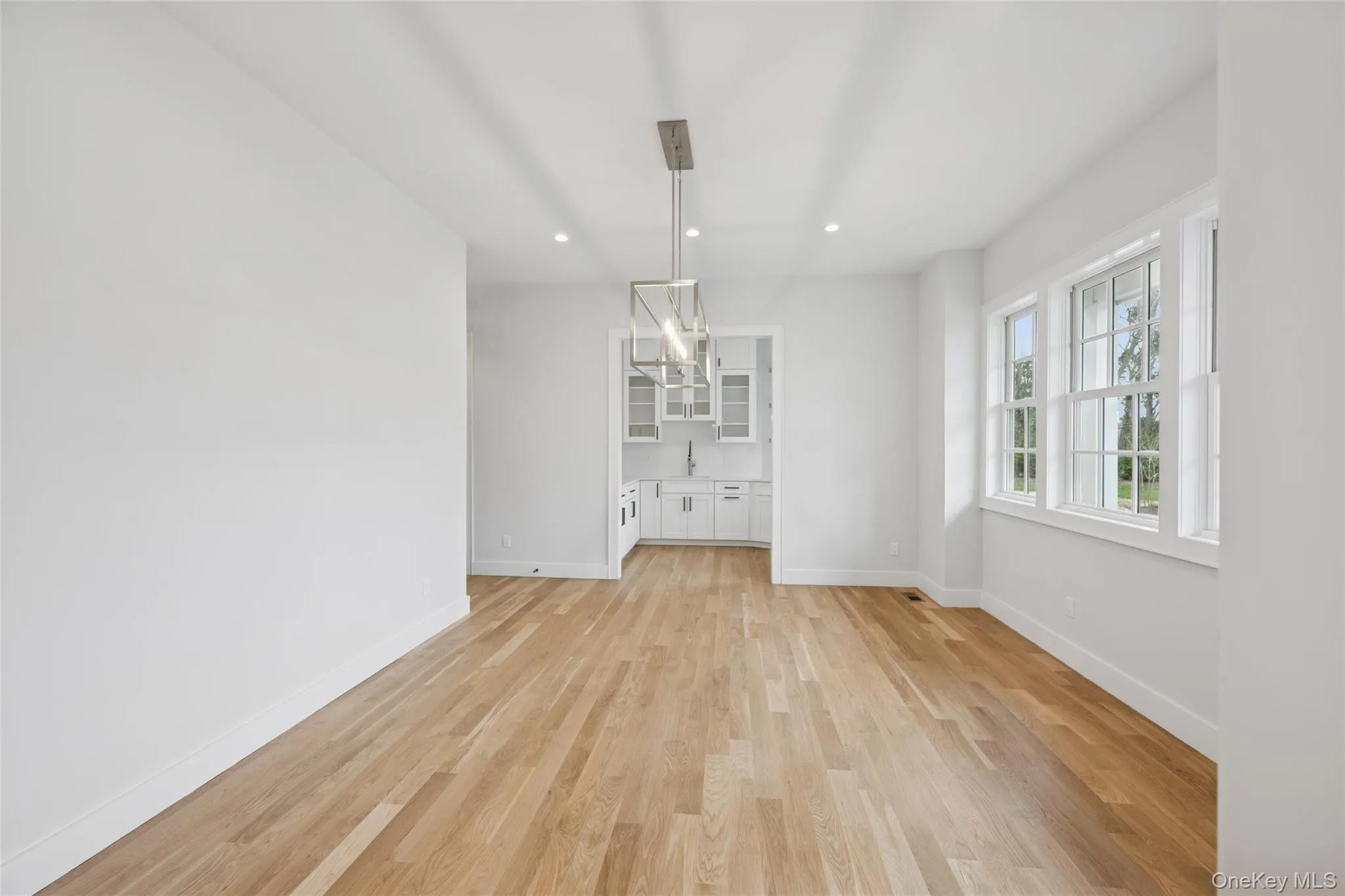 Dining area with light wood-type flooring, recessed lighting, and a chandelier Dining area with light wood-type flooring, recessed lighting, and a chandelier