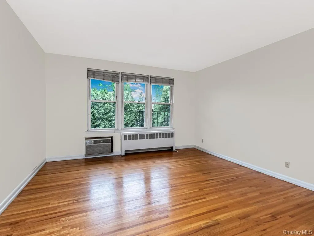 Hardwood flooring throughout featuring white baseboards Hardwood flooring throughout featuring white baseboards