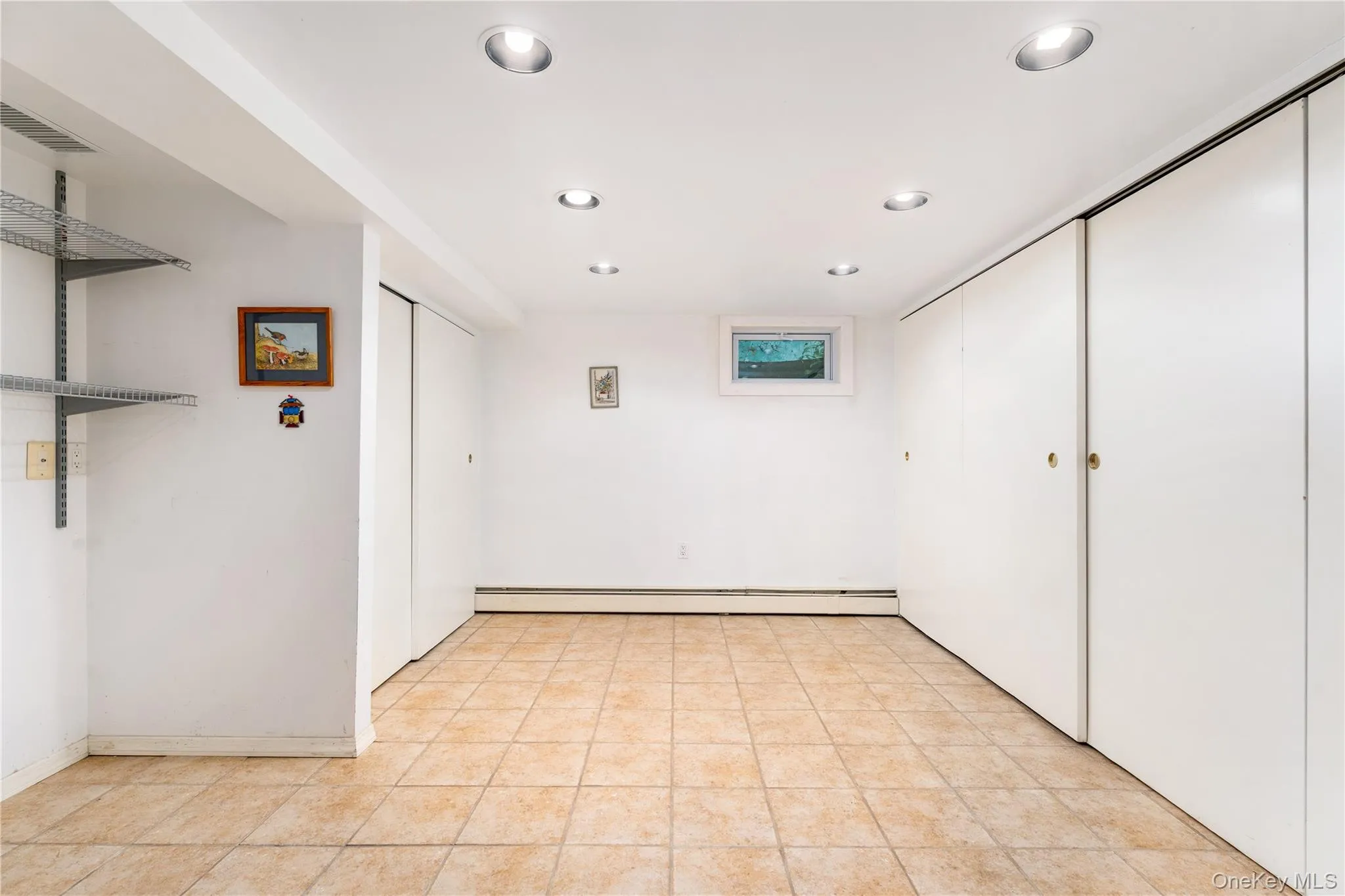 Finished basement with custom closet storage, baseboard heat, overhead light Finished basement with custom closet storage, baseboard heat, overhead light