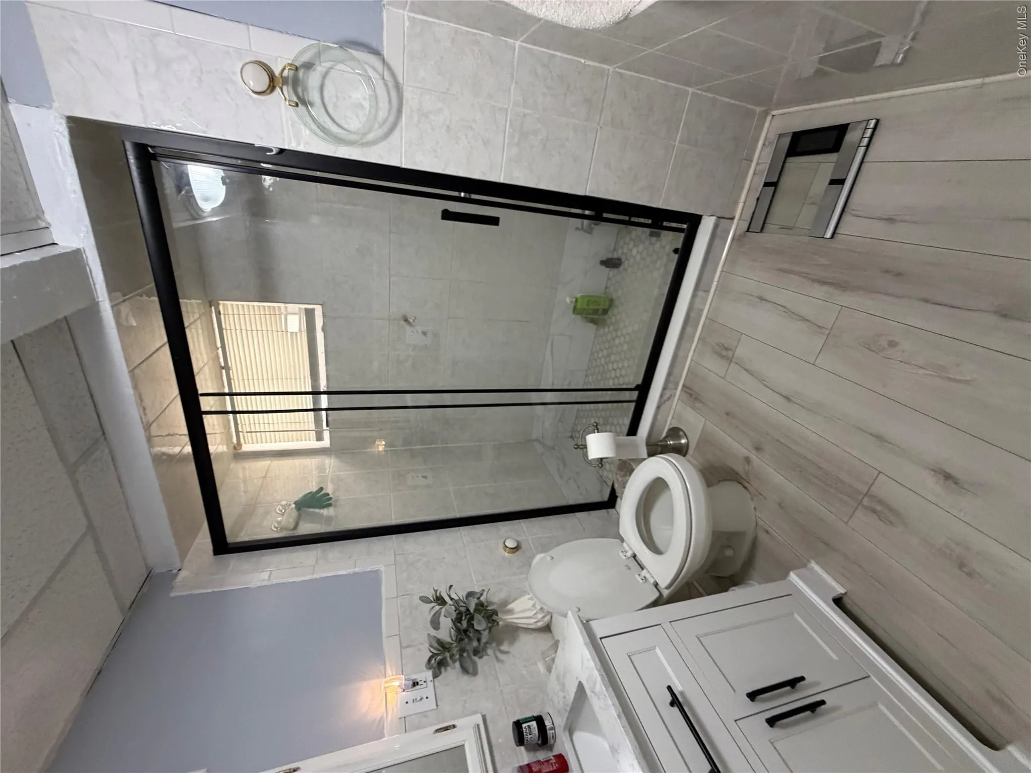 Contemporary bathroom featuring a glass-enclosed shower with a black frame and tiled walls Contemporary bathroom featuring a glass-enclosed shower with a black frame and tiled walls