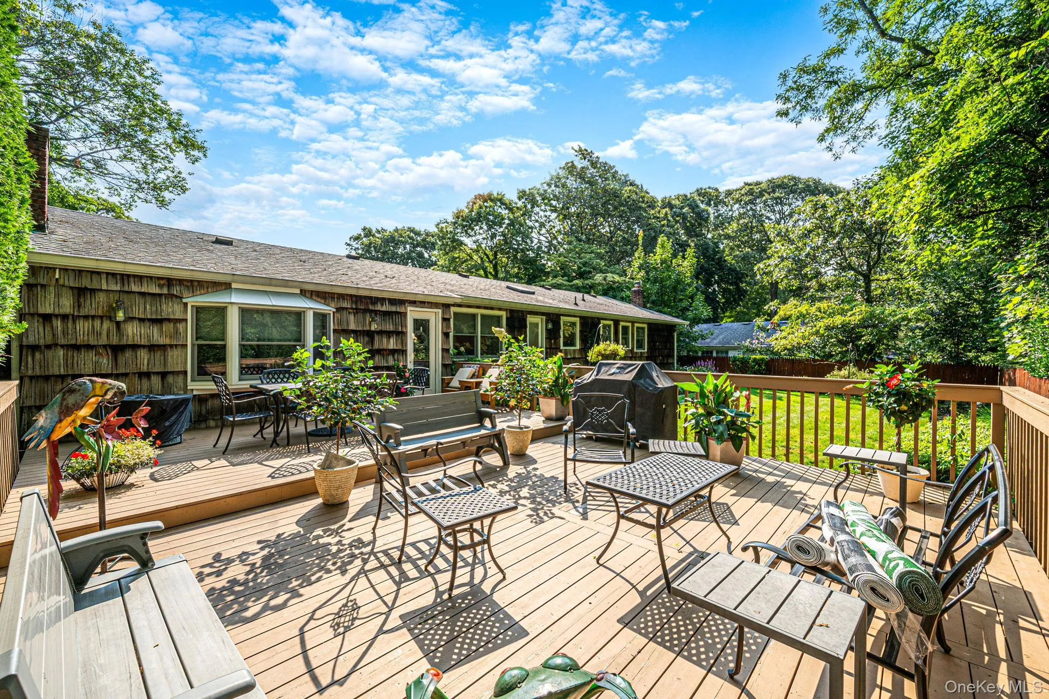 Expansive wood deck with a perimeter railing, overlooking a lush green lawn Expansive wood deck with a perimeter railing, overlooking a lush green lawn