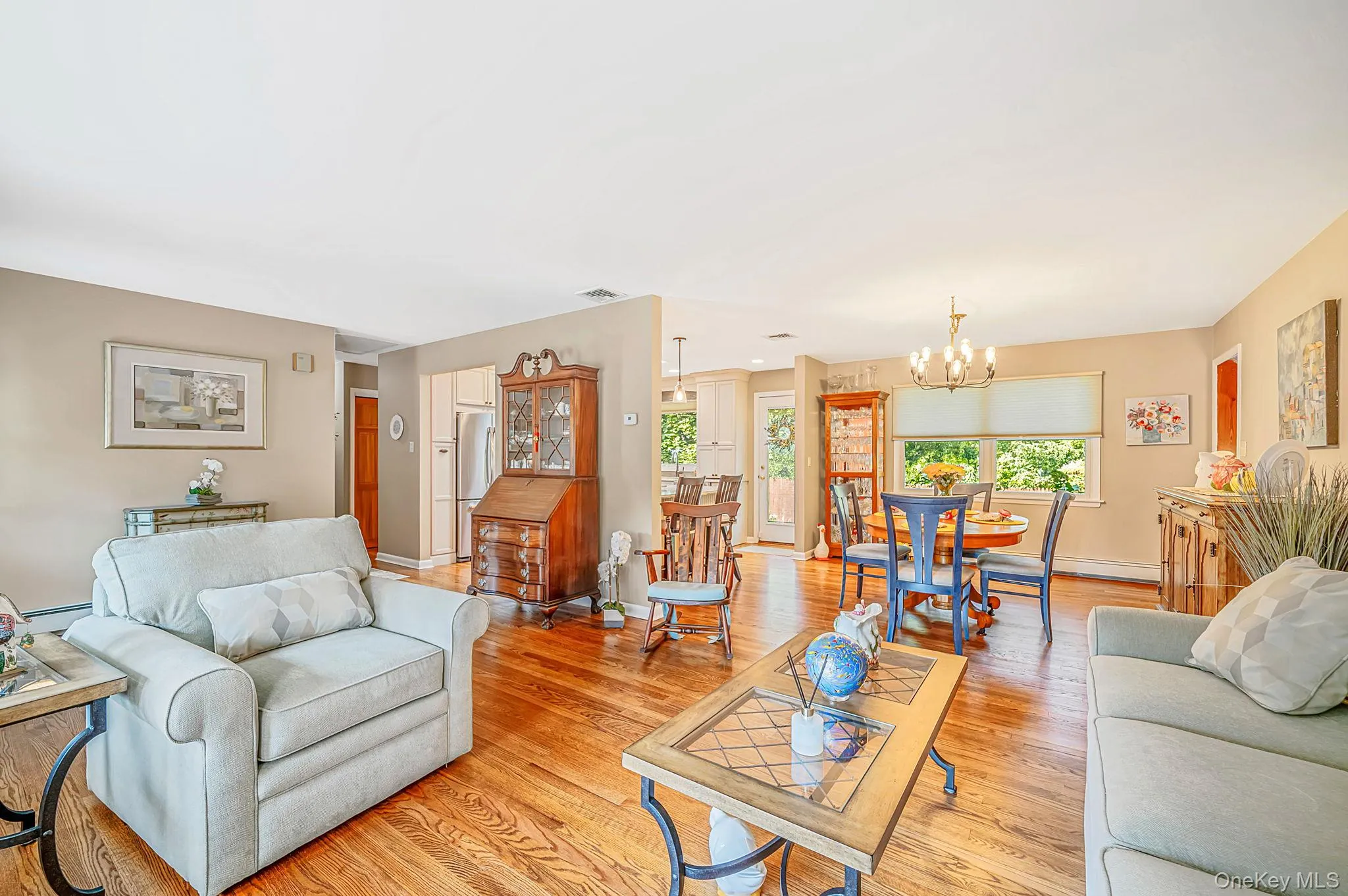Hardwood flooring throughout, recessed lighting, and a dining area with a chandelier Hardwood flooring throughout, recessed lighting, and a dining area with a chandelier