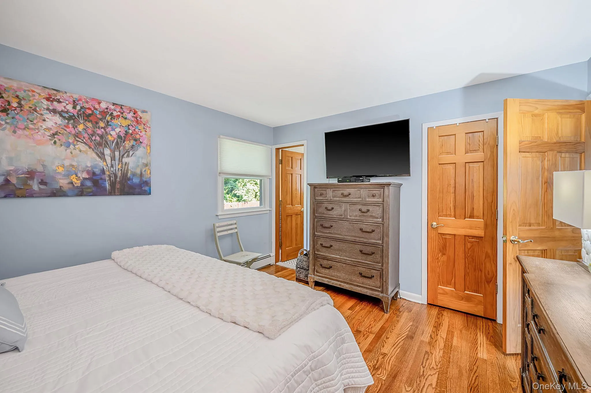 Hardwood flooring, light blue wall paint, and a window with natural light Hardwood flooring, light blue wall paint, and a window with natural light