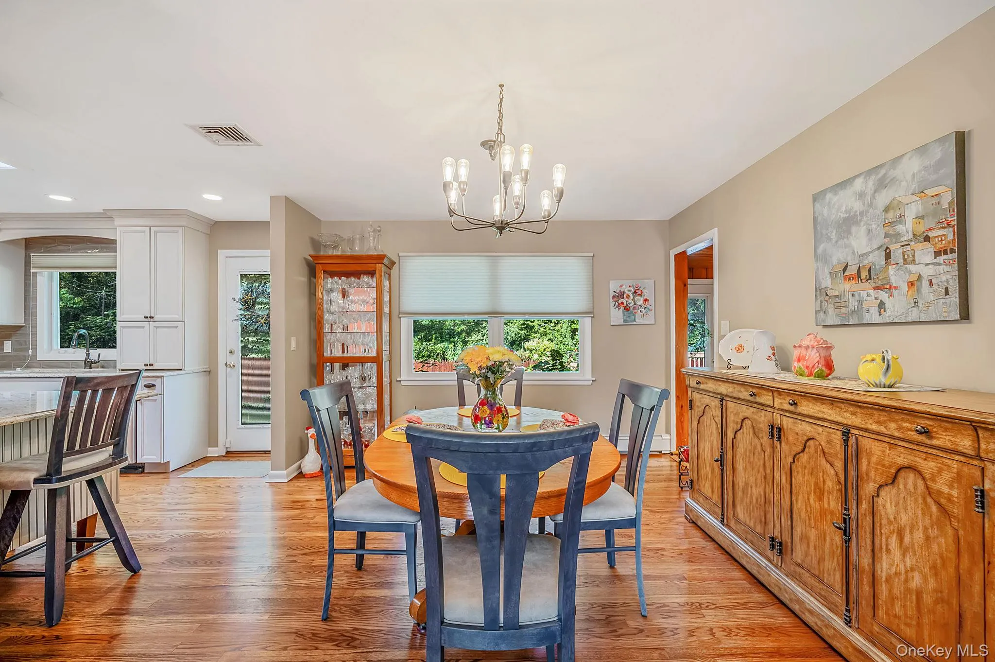 Hardwood flooring throughout, white cabinetry in kitchen, recessed lighting, double-hung windows, and a built-in display cabinet Hardwood flooring throughout, white cabinetry in kitchen, recessed lighting, double-hung windows, and a built-in display cabinet