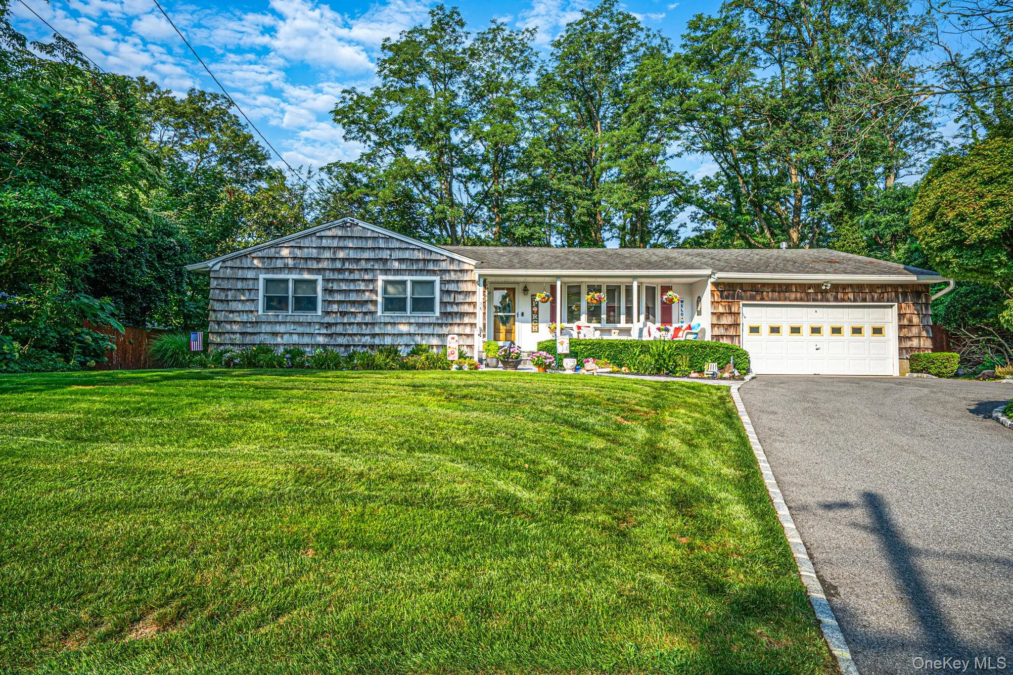 Shingle-sided residence with an attached garage, covered front porch, and paved driveway Shingle-sided residence with an attached garage, covered front porch, and paved driveway