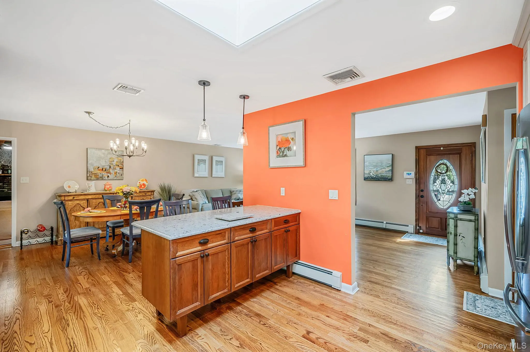 Hardwood flooring throughout, kitchen island with stone countertop, two pendant lights, recessed lighting, and a skylight Hardwood flooring throughout, kitchen island with stone countertop, two pendant lights, recessed lighting, and a skylight
