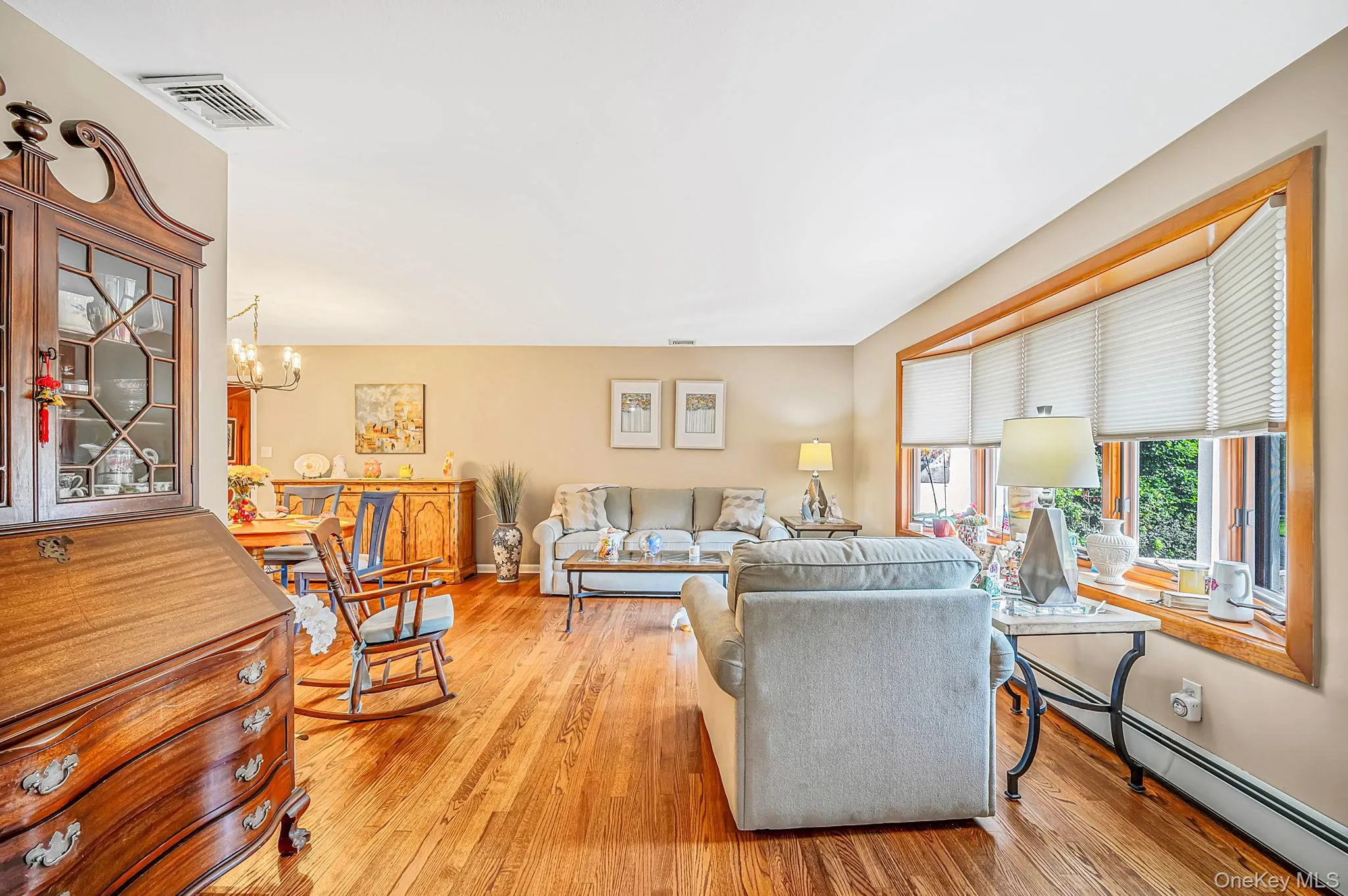 Hardwood flooring throughout, neutral wall paint, and a bay window with blinds Hardwood flooring throughout, neutral wall paint, and a bay window with blinds