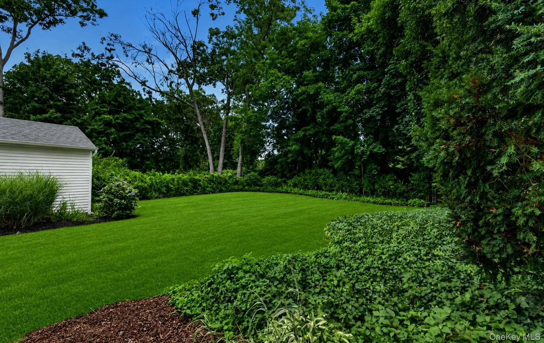 Spacious outdoor area featuring a lush green lawn Spacious outdoor area featuring a lush green lawn