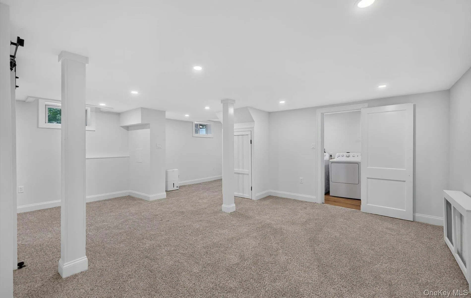 Spacious finished lower level with recessed lighting, light gray carpet, and white trim Spacious finished lower level with recessed lighting, light gray carpet, and white trim
